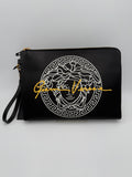 Clutch en cuir signature Versace La Medusa, élégante et sophistiquée, avec logo emblématique en or sur le devant.