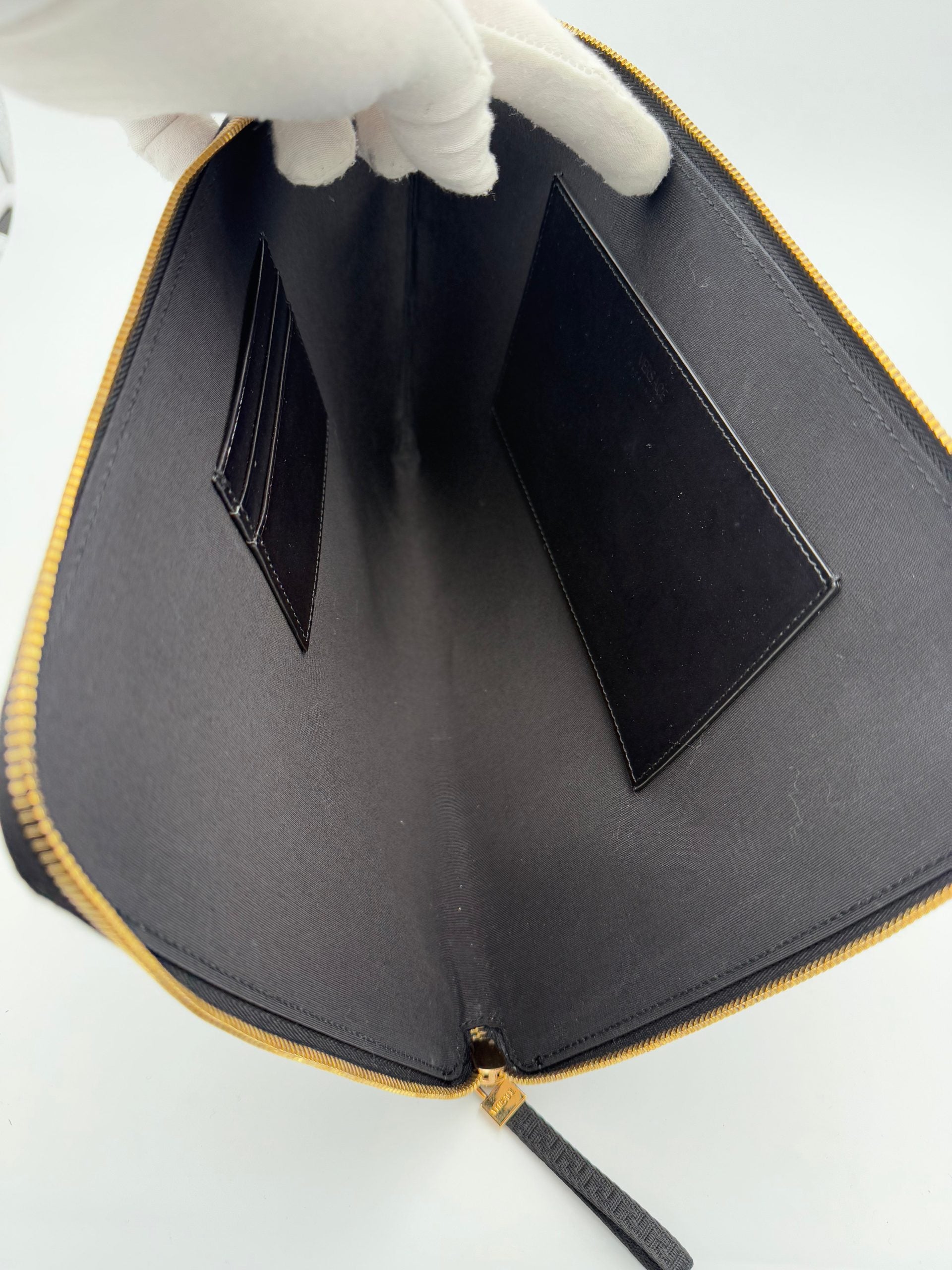 Clutch en cuir signature Versace La Medusa, élégante pochette noire avec logo emblématique et détails luxueux.