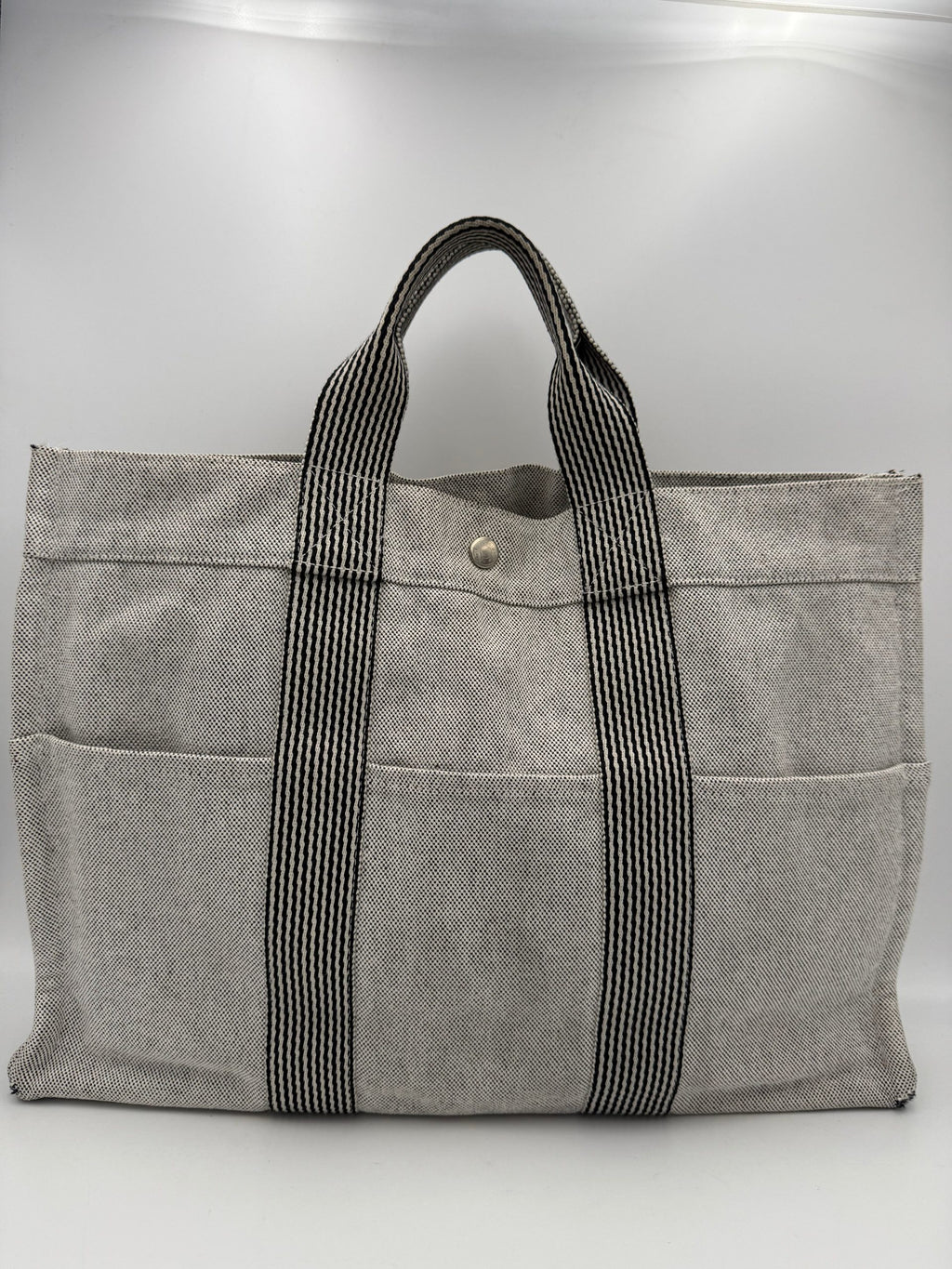 Sac à main Hermès HERMÈS HERLINE en cuir avec détails élégants, porté ouvert pour révéler l'intérieur sophistiqué.