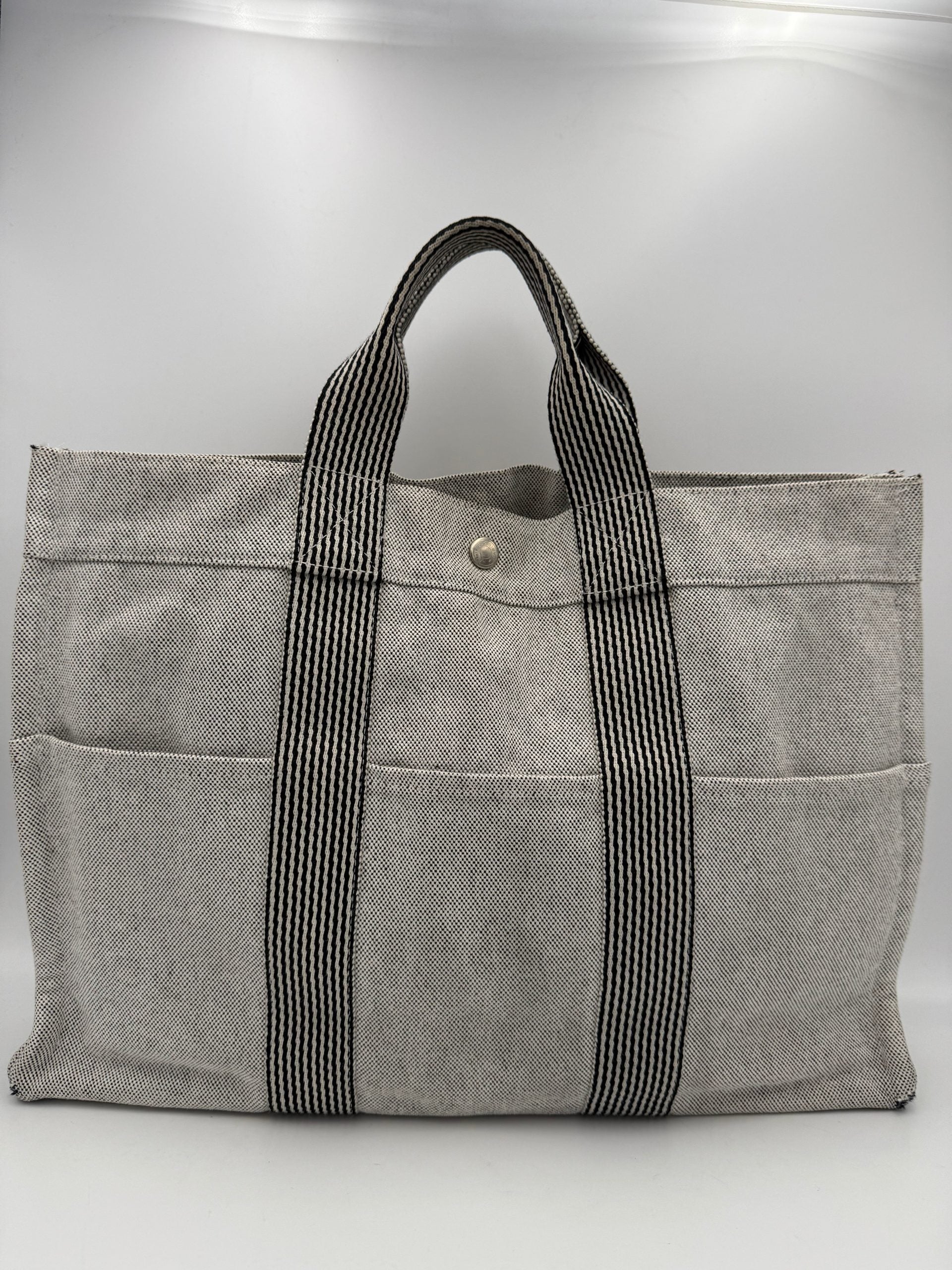 Sac à main Hermès HERMÈS HERLINE en cuir avec détails élégants, porté ouvert pour révéler l'intérieur sophistiqué.