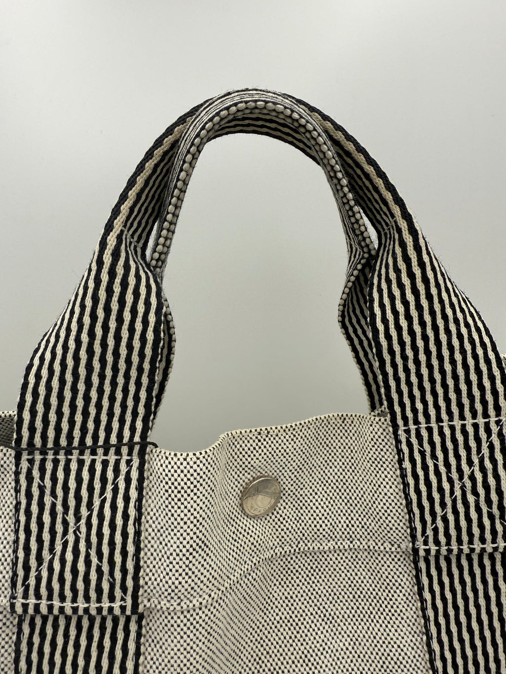 Sac à main Hermès HERLINE en cuir élégant, avec poignée et détails raffinés, sur fond neutre.