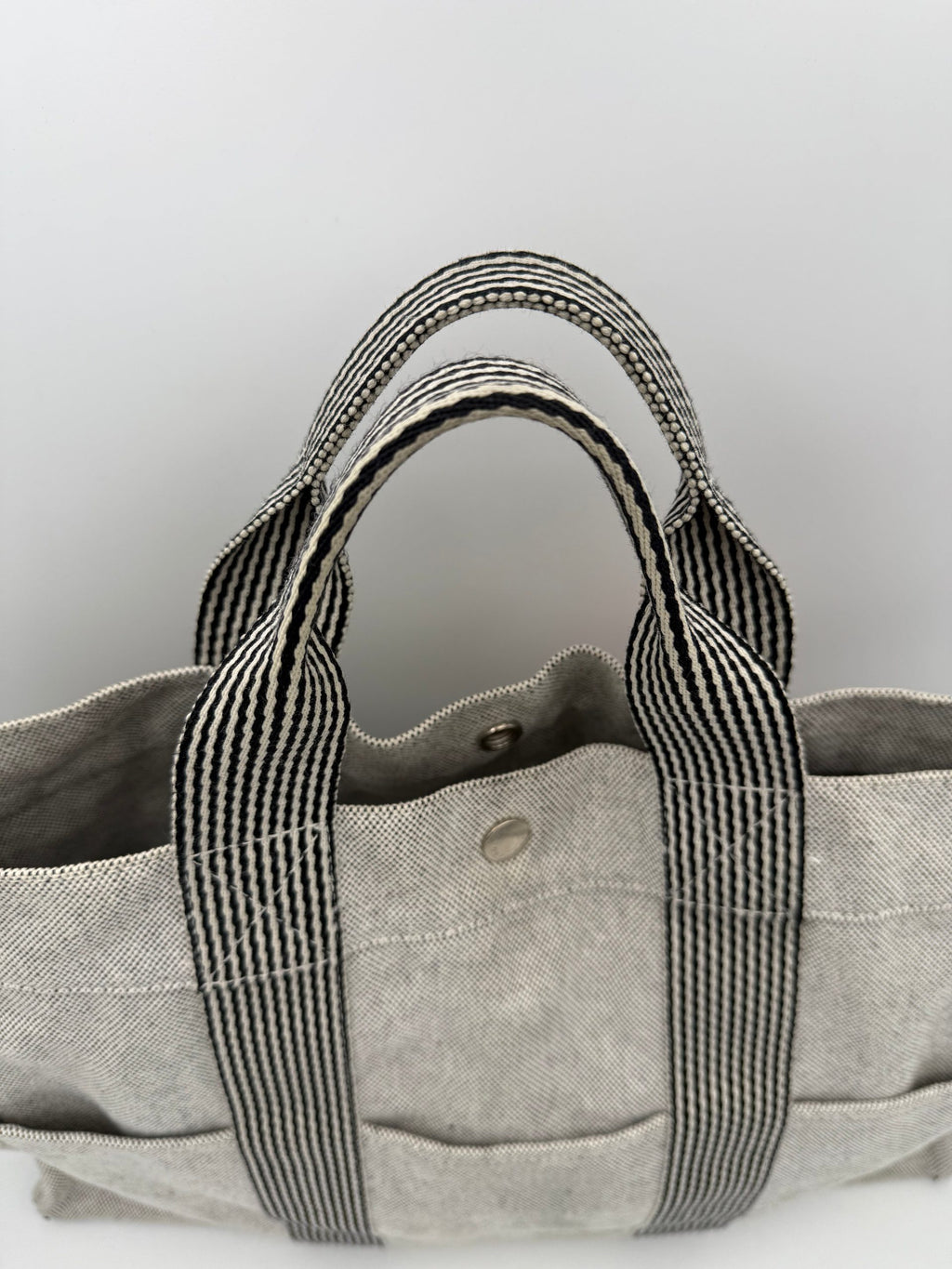 Sac à main Hermès HERLINE en cuir, avec poignée élégante et logo Hermès visible, couleur beige clair.