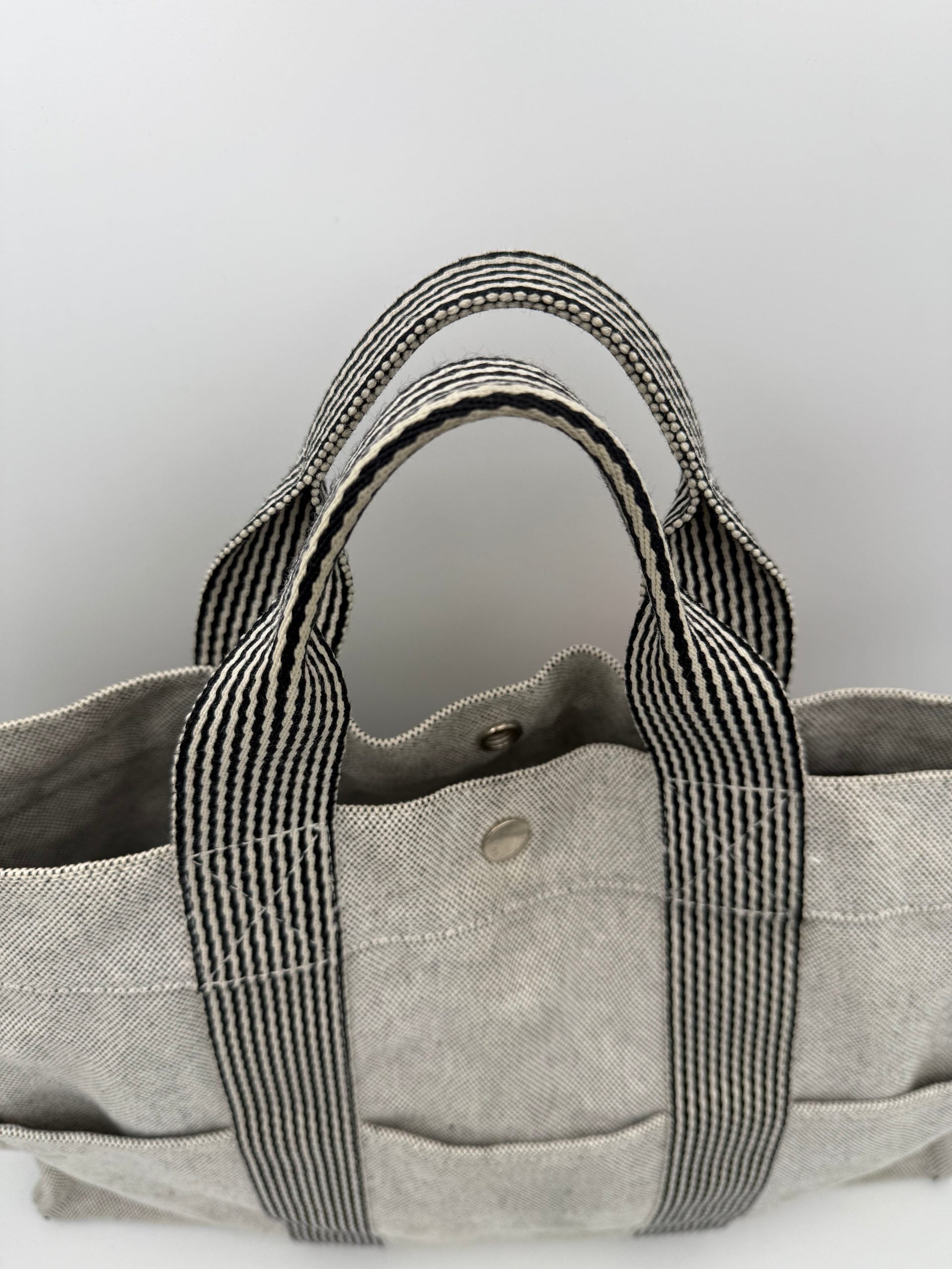 Sac à main Hermès HERLINE en cuir, avec poignée élégante et logo Hermès visible, couleur beige clair.