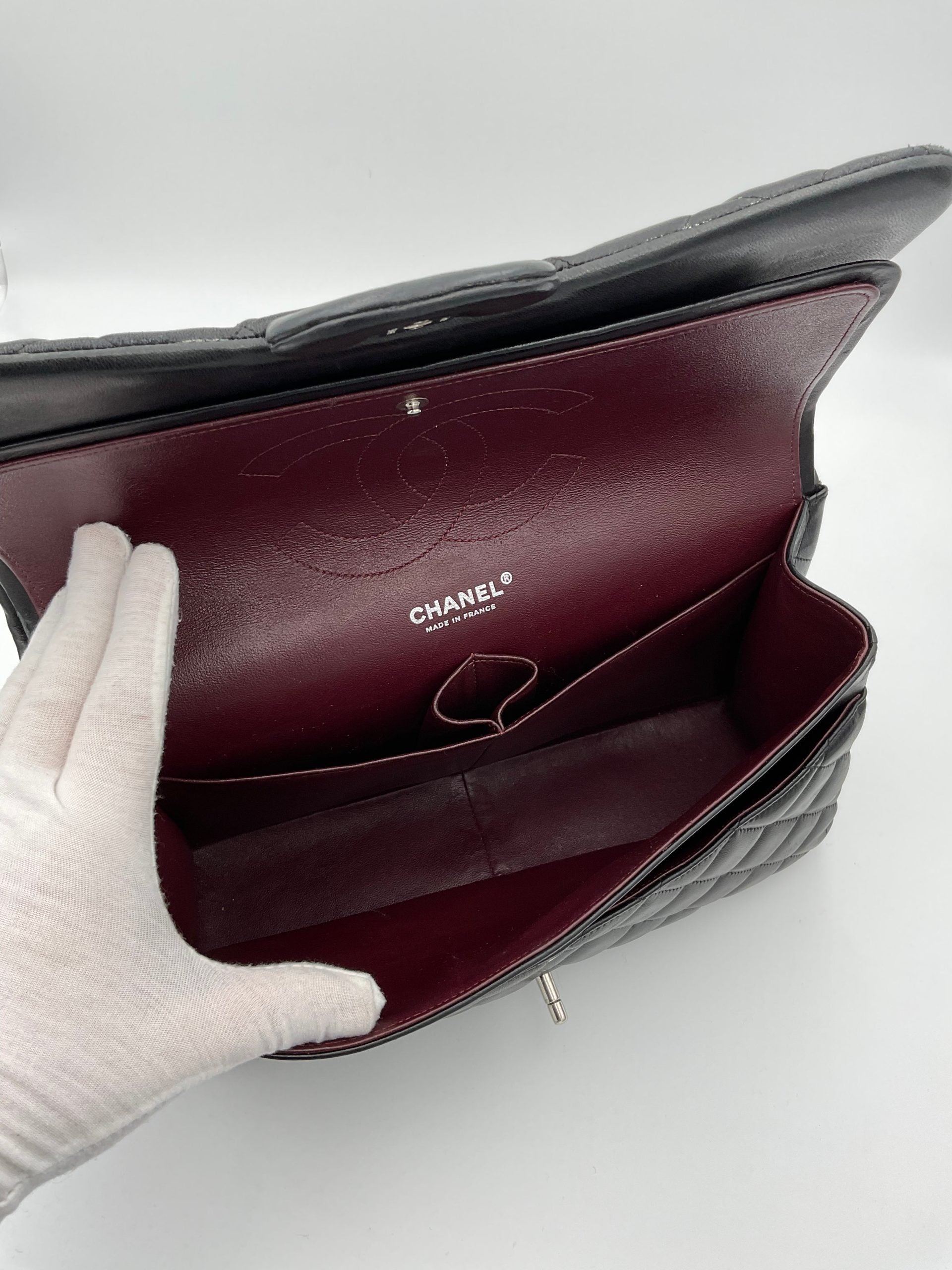 Sac à main Chanel Timeless Classique Jumbo en cuir noir avec matelassage et logo emblématique en or.