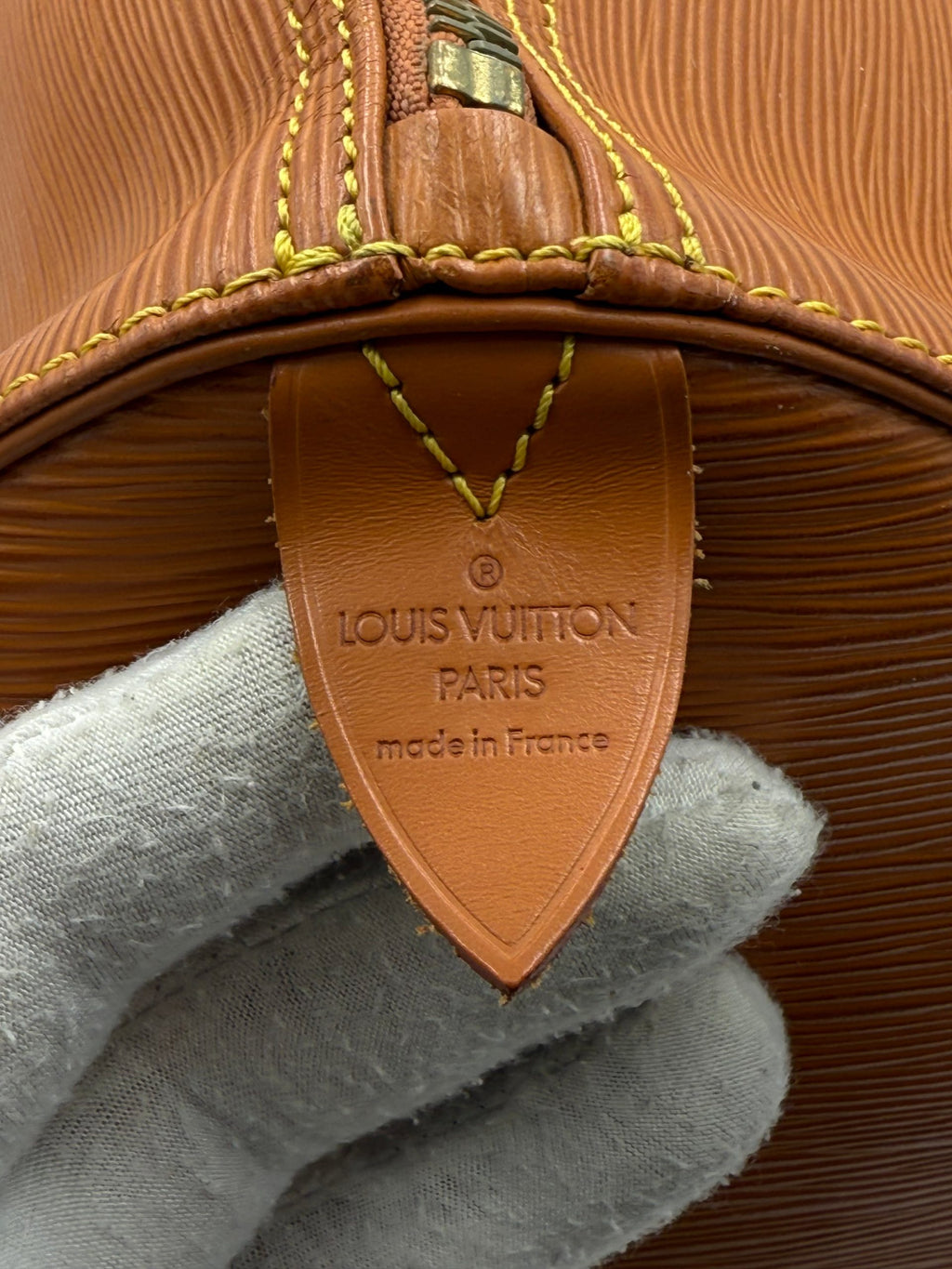 Sac à main Louis Vuitton Keepall 50 en cuir EPI marron, sac de voyage élégant avec poignées et fermeture zippée.