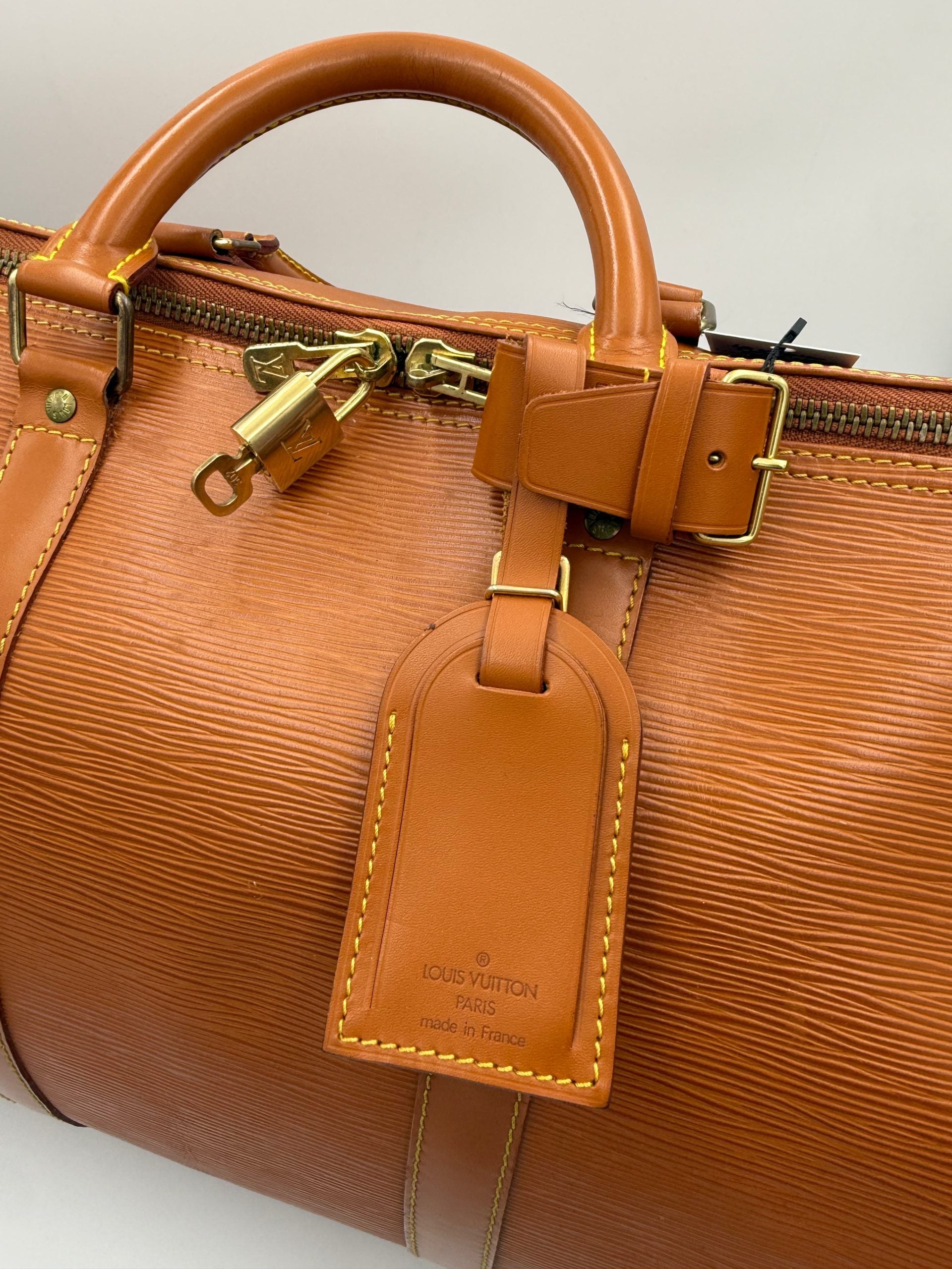 Sac à main Louis Vuitton Keepall 50 en cuir EPI marron, sac de voyage élégant et spacieux avec poignées en cuir.