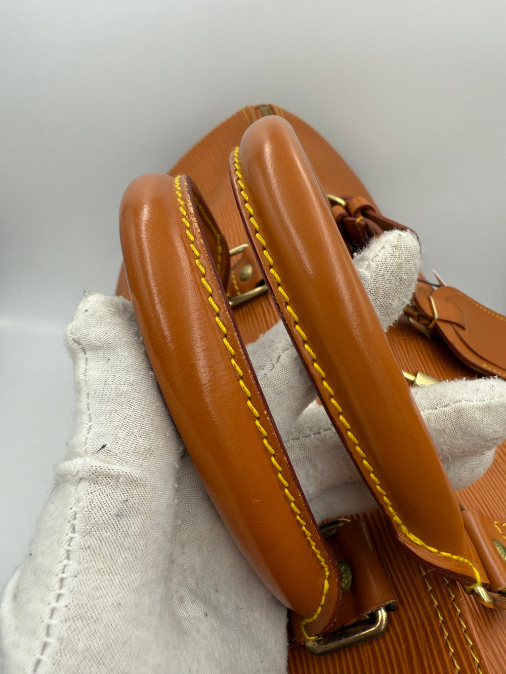Sac à main Louis Vuitton Keepall 50 en cuir EPI marron, sac de voyage élégant avec poignées et fermeture zippée.