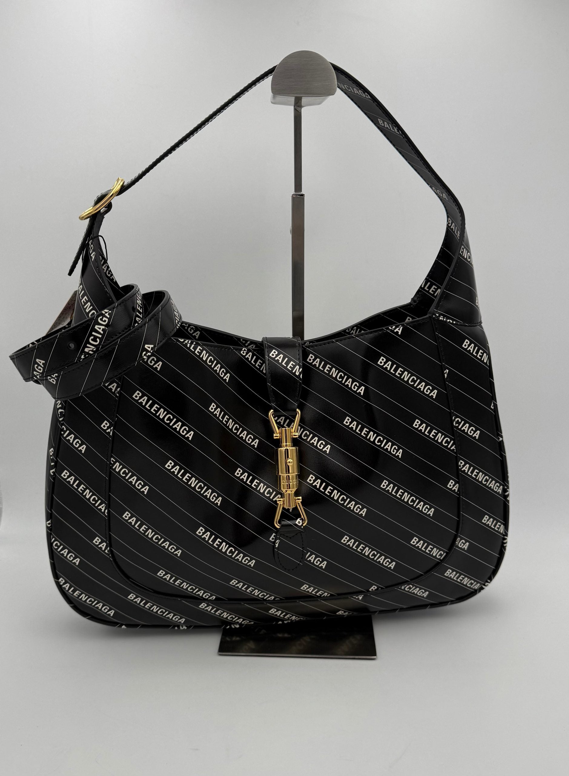 Sac à main Gucci Jackie 1961 en cuir avec logo en métal doré et bandoulière, élégant et classique.