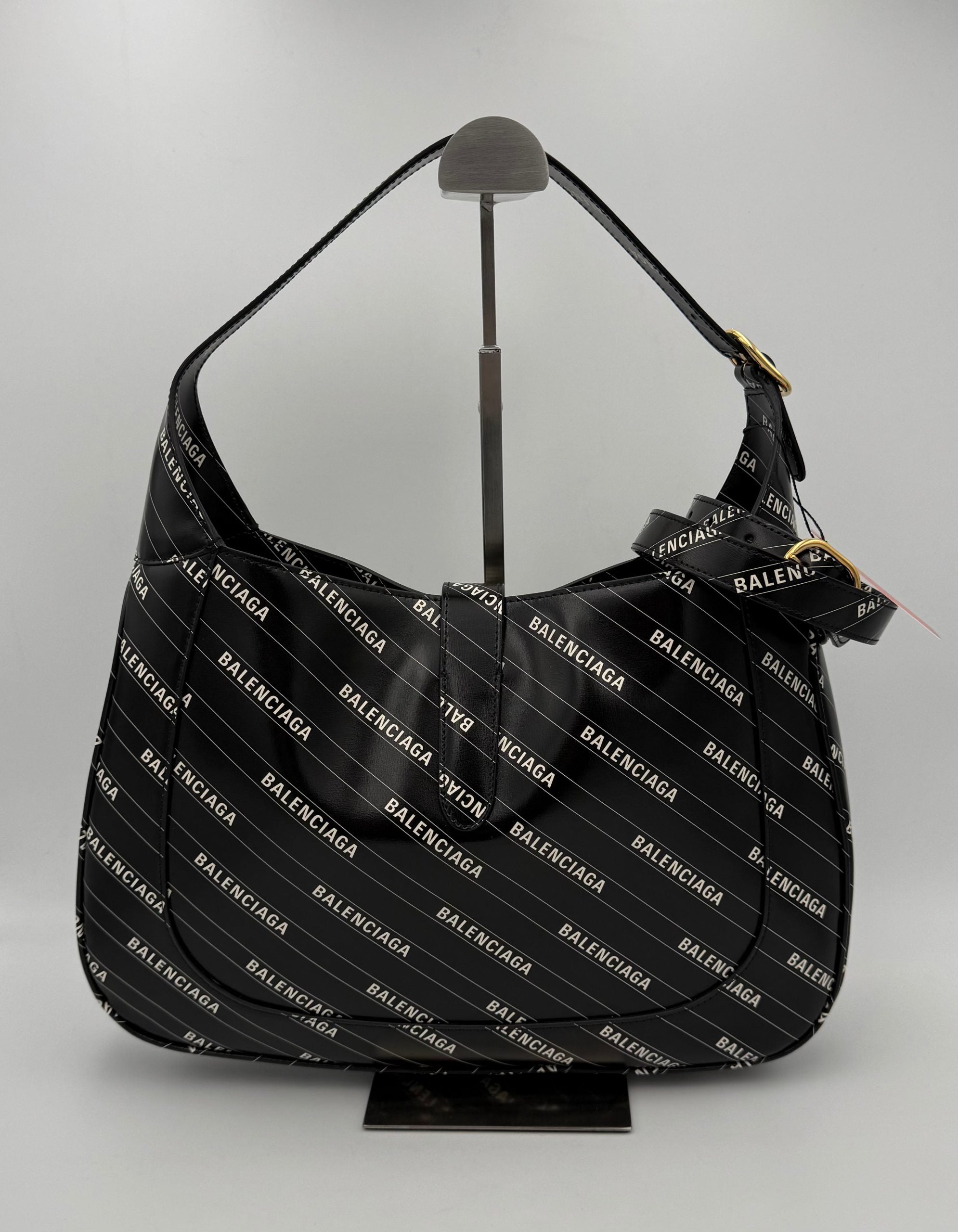 Sac à main Gucci Jackie 1961 en cuir avec logo GG, doré et élégant, porté sur l'épaule.