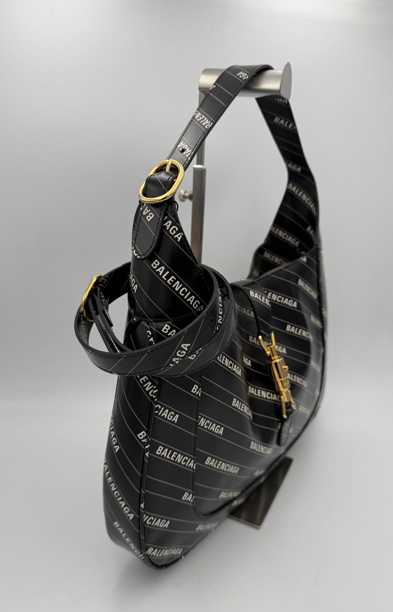 Sac à main Gucci Jackie 1961 en cuir avec logo GG, poignées en cuir et détails élégants, sur fond neutre.