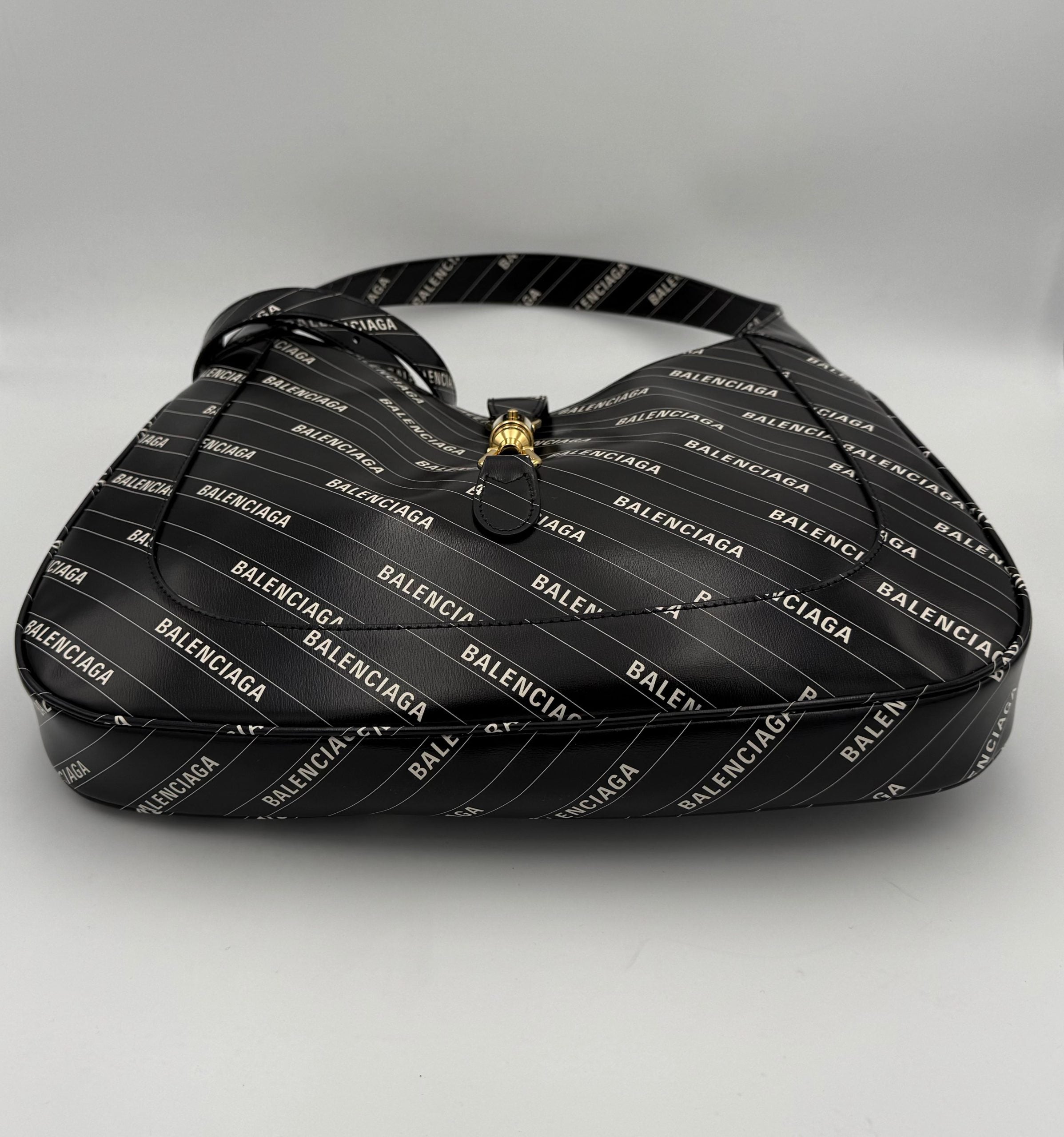 Sac à main Gucci Jackie 1961 en cuir noir avec détails dorés et bandoulière, style élégant et classique.