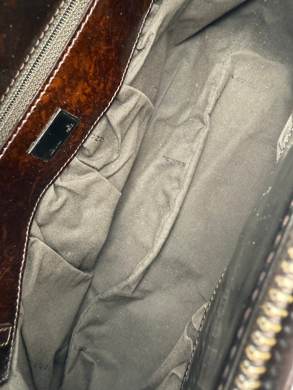 Sac à main Fendi FF Zucca TO YOU avec logo Fendi, motif monogramme brun et beige, porté avec poignée en cuir.