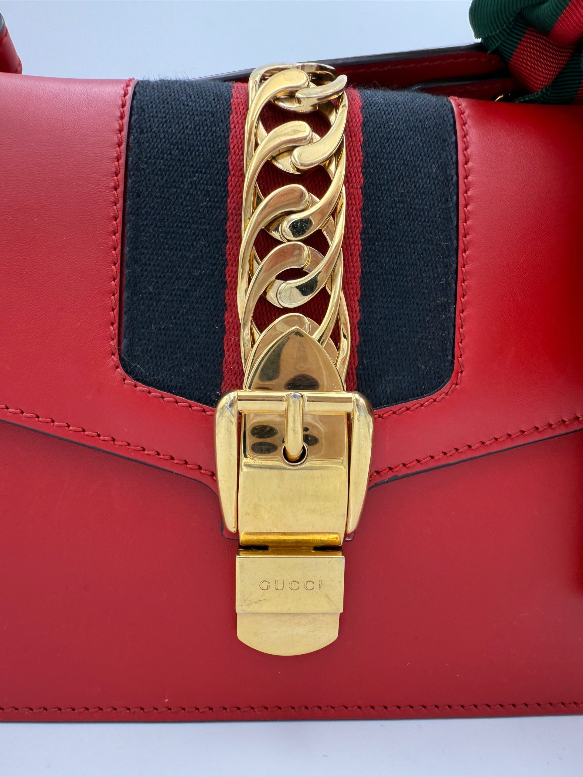 Sac à main Gucci Sylvie rouge en cuir avec bandoulière chaîne, élégant et tendance.