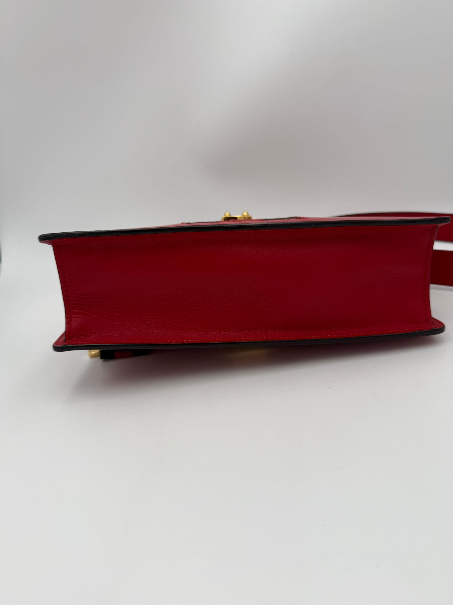 Sac à main rouge Gucci Sylvie, élégant et en cuir, avec détails sophistiqués et poignée en chaîne, pour un style chic.