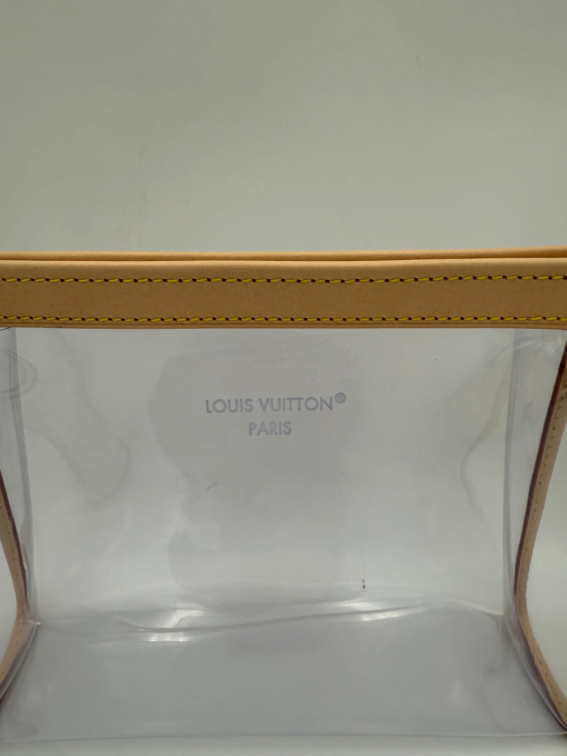 Pochette transparente Monogram Louis Vuitton MM avec logo Louis Vuitton visible, finition élégante et design iconique.
