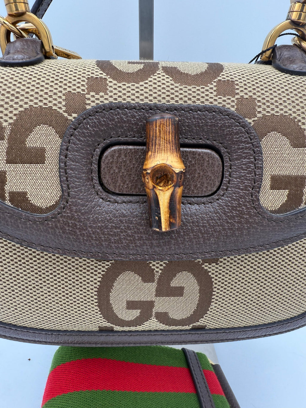 Sac à main Gucci Bamboo 1947 GG en toile, avec poignée en bambou et logo Gucci visible sur le devant.