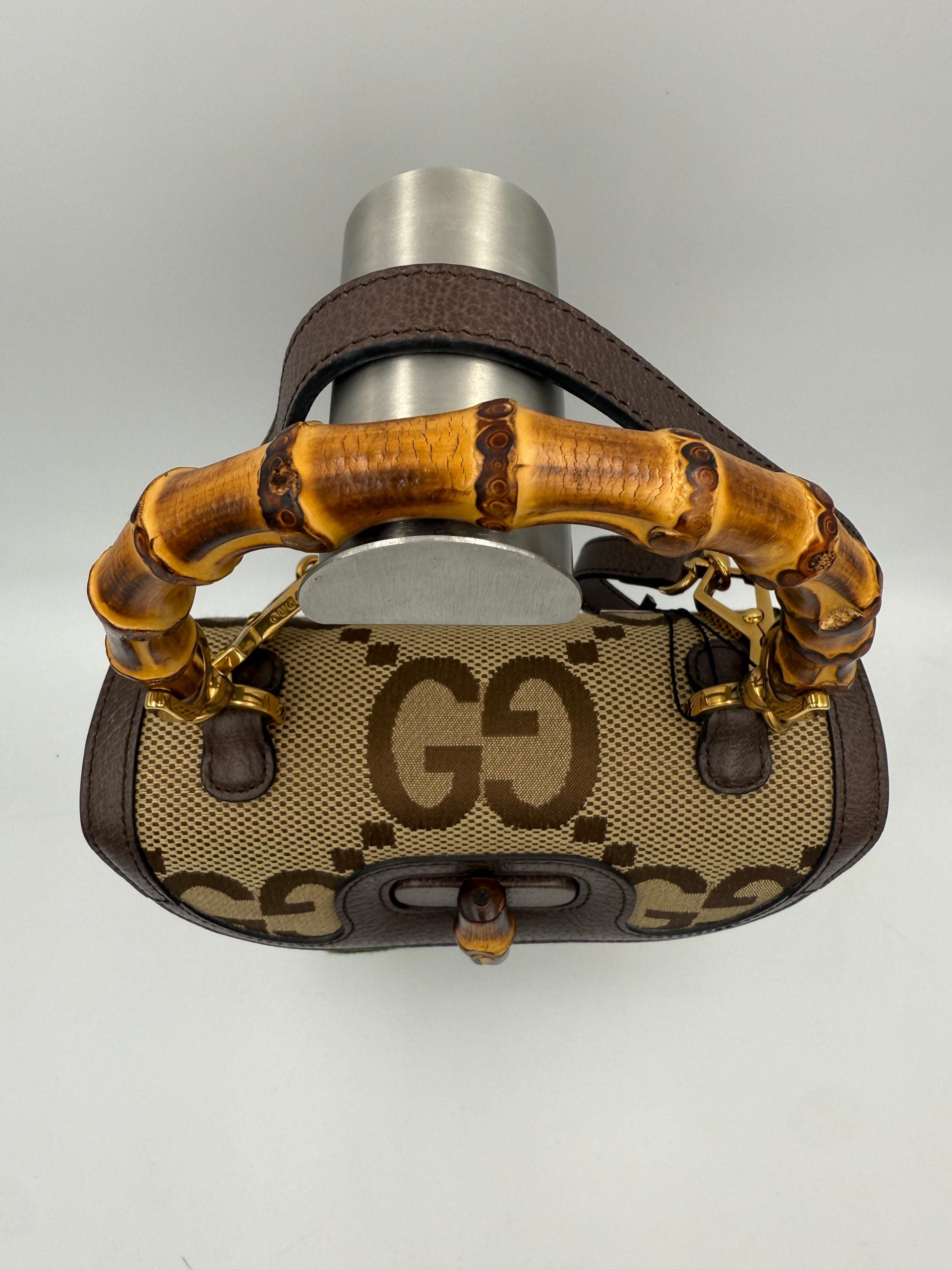 Sac à main Gucci Bamboo 1947 GG en toile avec poignée en bambou, élégant et emblématique, posé sur une surface claire.