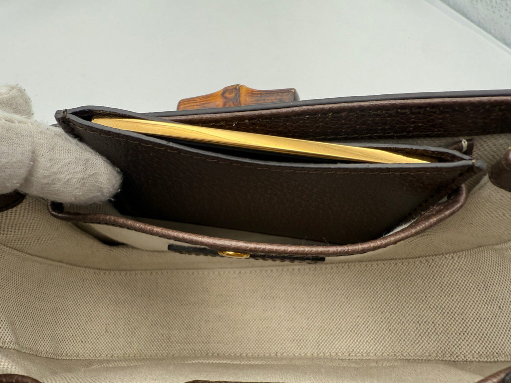 Sac à main Gucci Bamboo 1947 GG en toile, avec poignée en bambou et logo Gucci, visible en gros plan.