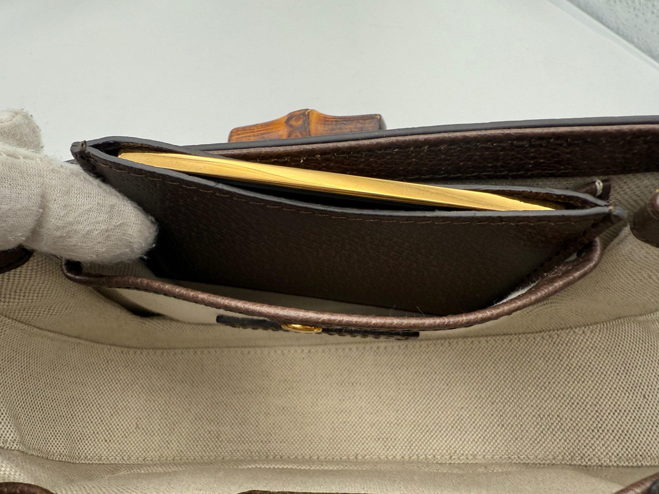 Sac à main Gucci Bamboo 1947 GG en toile, avec poignée en bambou et logo Gucci, visible en gros plan.