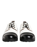 Chaussures derby en cuir noir et blanc de Dolce & Gabbana, élégantes et sophistiquées, visibles en gros plan.