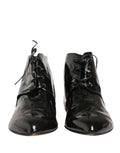 Chaussures bottines en cuir noir Dolce & Gabbana, élégantes et sophistiquées, avec des détails en cuir verni et une semelle en caoutchouc.