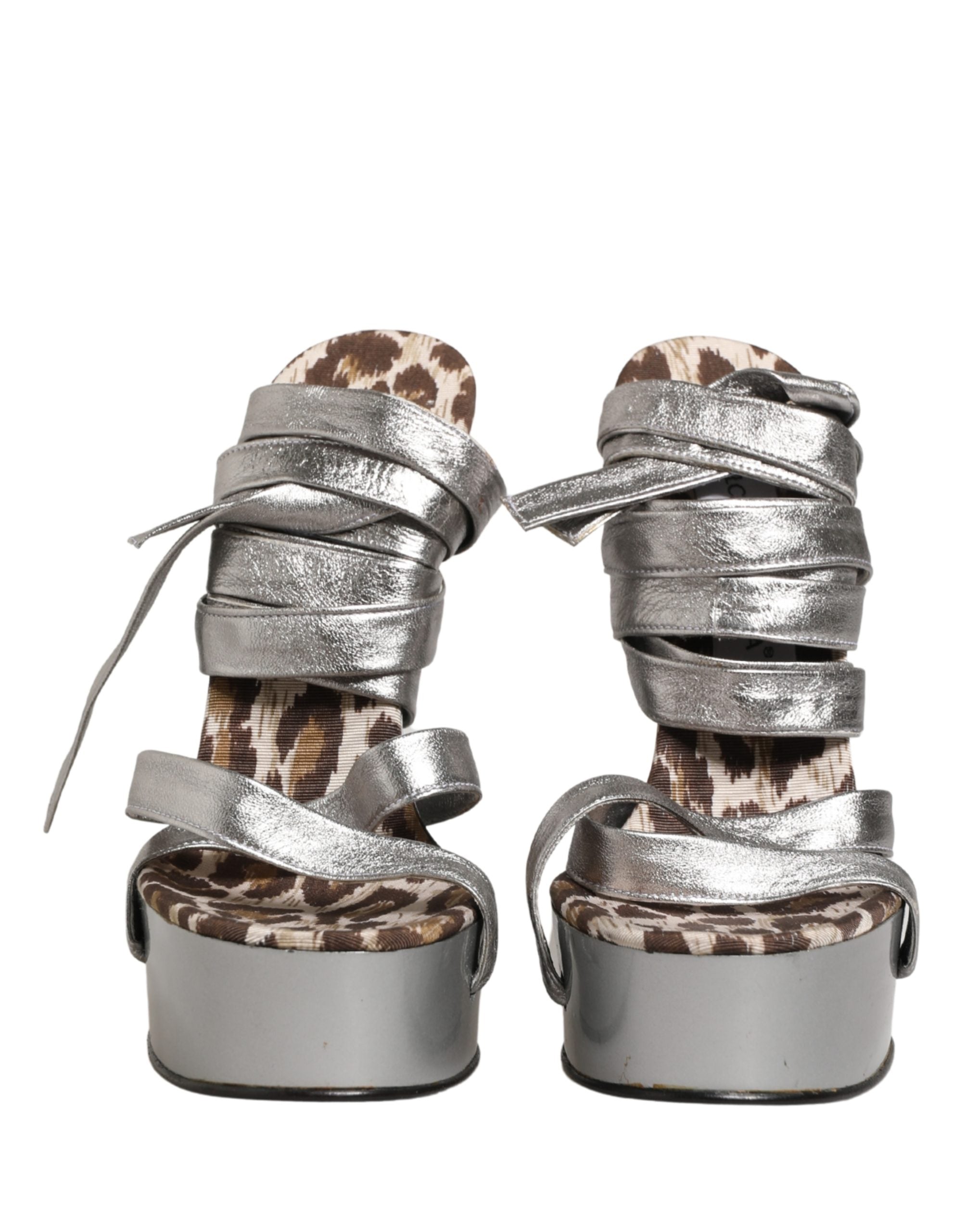 Sandales à plateforme en cuir argenté Dolce & Gabbana avec talons wedges, design élégant et moderne, visibles en gros plan.