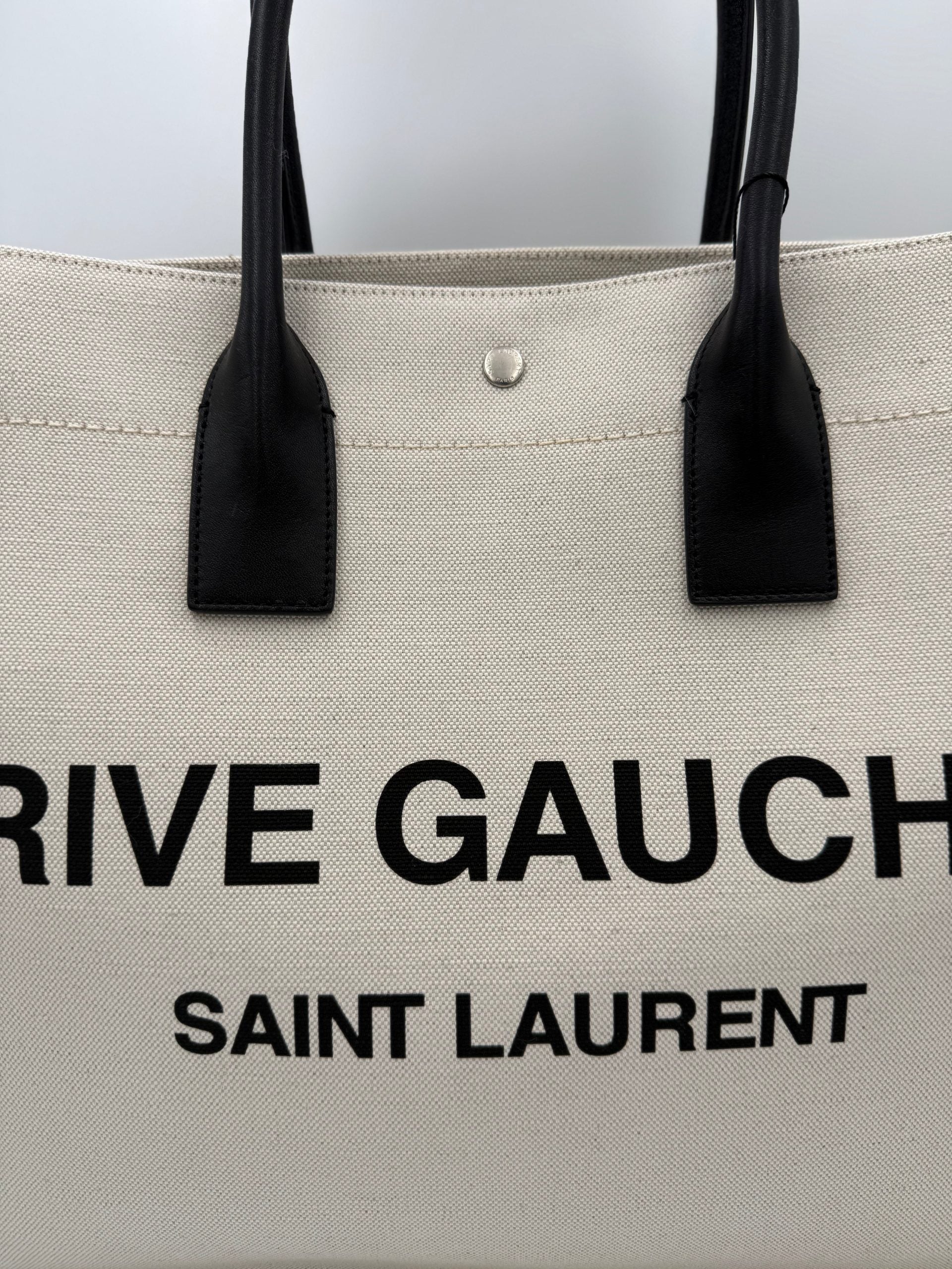 Grand sac cabas Saint Laurent Rive Gauche, en toile noire avec logo, idéal pour un style élégant et pratique.