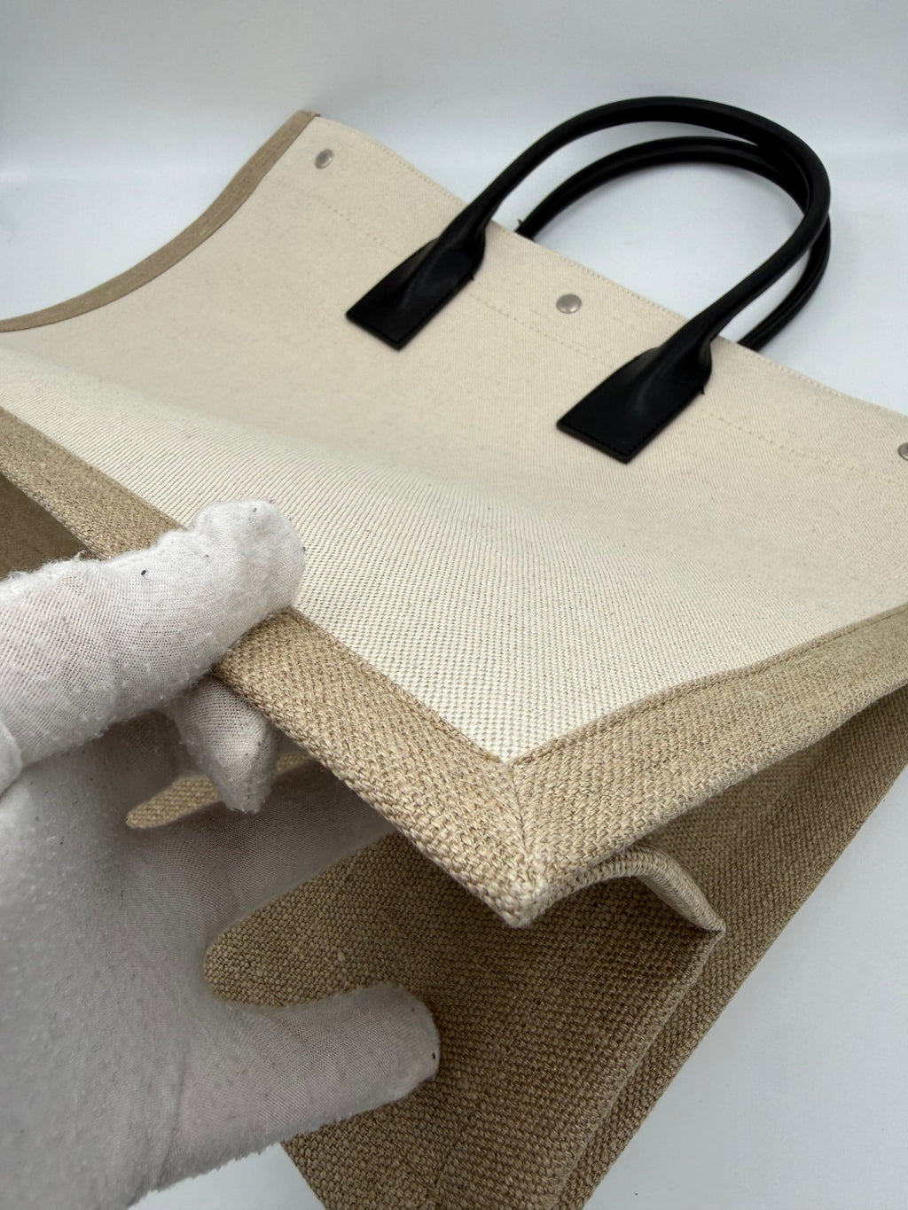 Grand sac cabas Saint Laurent Rive Gauche en toile noire avec poignées en cuir, pour un style élégant et pratique.
