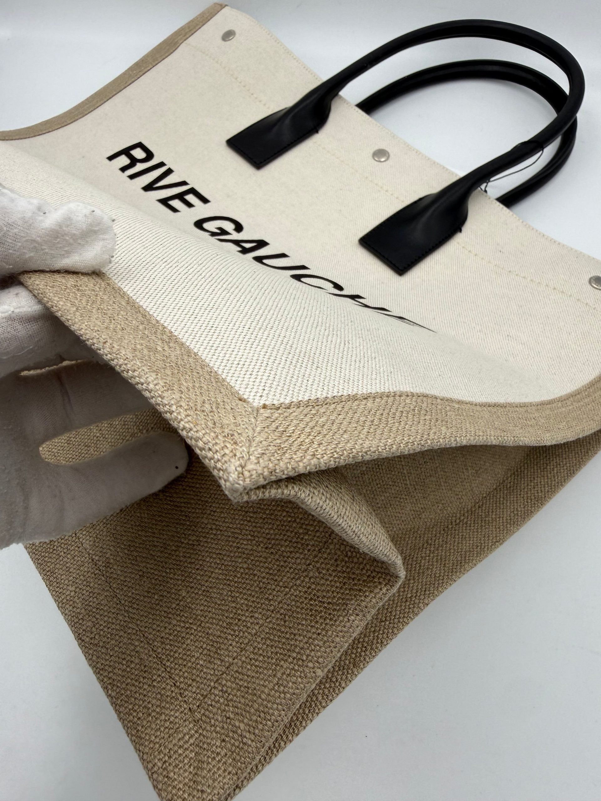 Grand sac cabas Saint Laurent Rive Gauche, en cuir noir avec logo emblématique, porté sur l'épaule ou à la main.