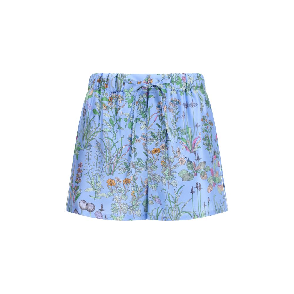 Shorts Bermuda en soie bleue de Gucci, coupe décontractée avec logo Gucci visible sur la ceinture, élégance et confort.