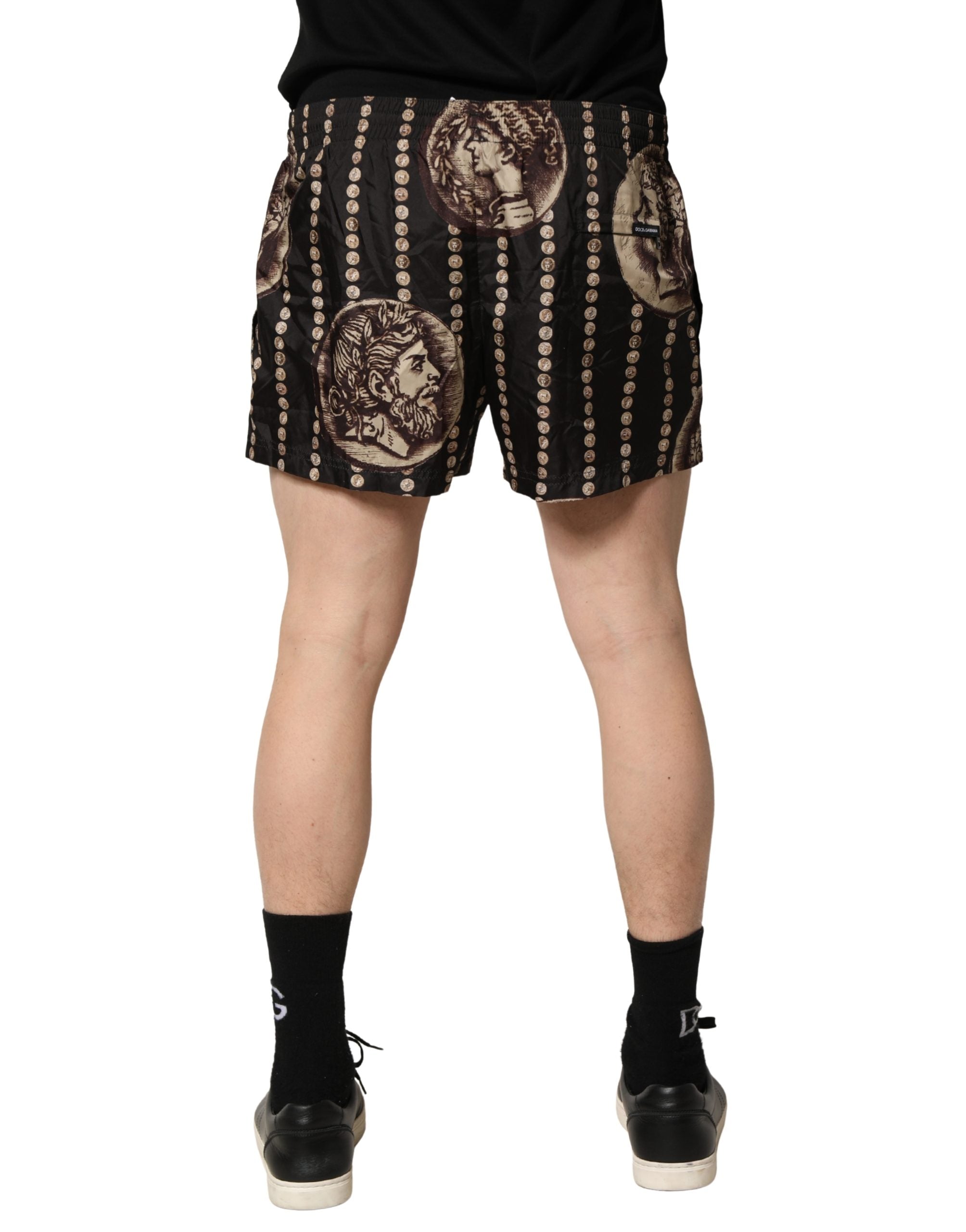 Shorts de bain noirs Dolce & Gabbana avec motif romain en pièces de monnaie, mode élégante pour la plage.