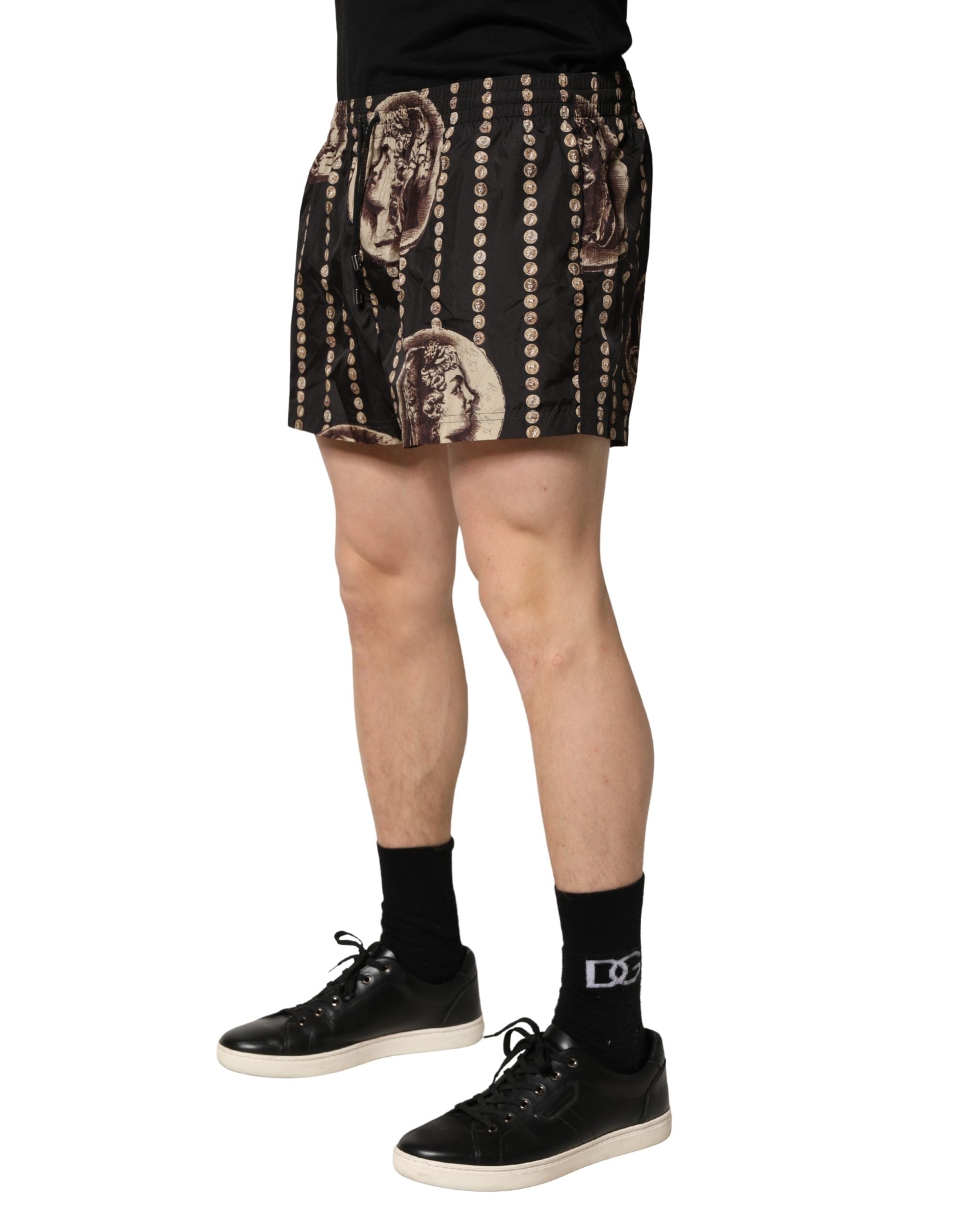 Maillot de bain Dolce & Gabbana avec motif de pièces romaines noires, style élégant et confortable pour la plage.