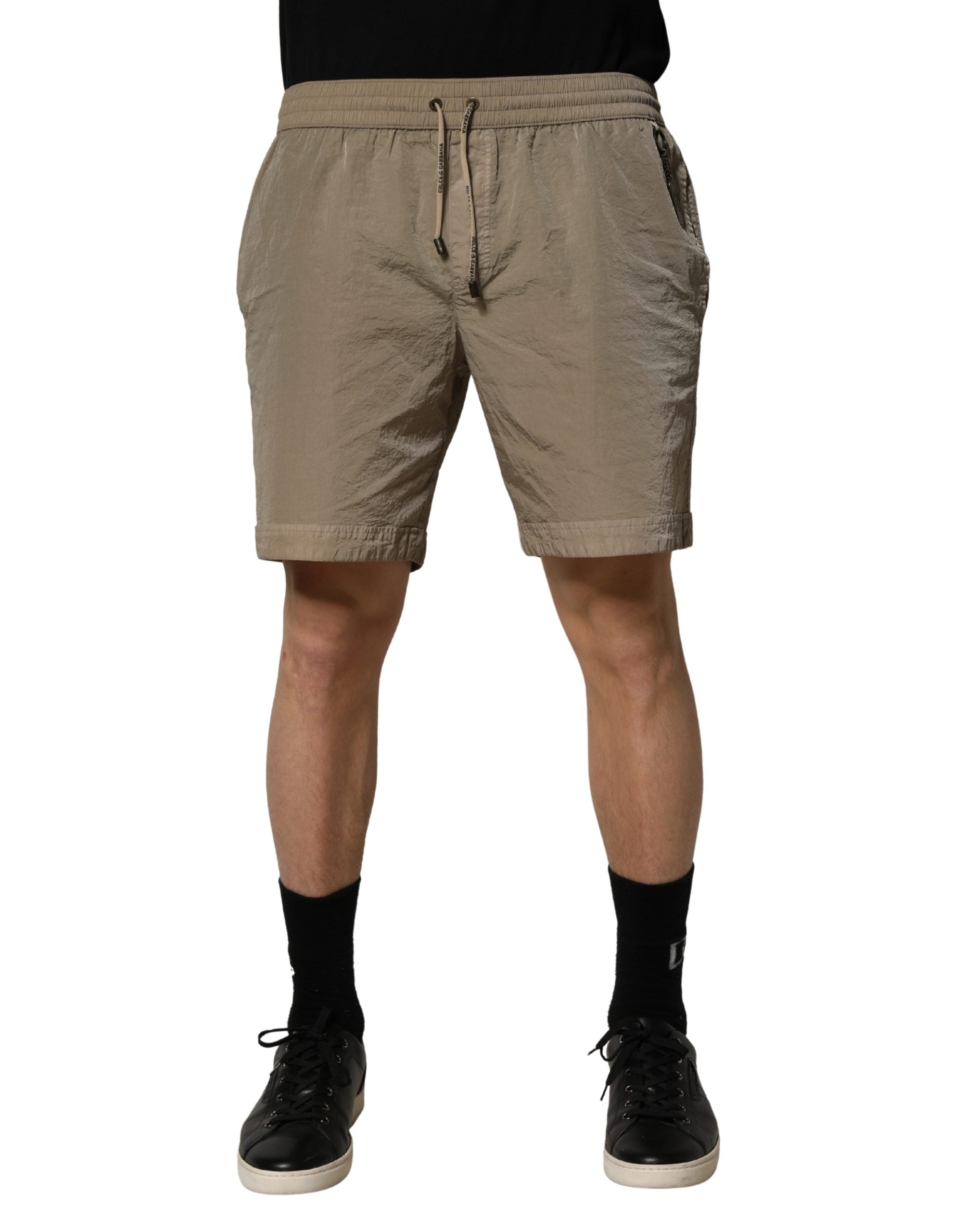 Shorts de bain en nylon marron avec cordon de serrage de la marque Dolce & Gabbana, visibles en détail dans l'image.