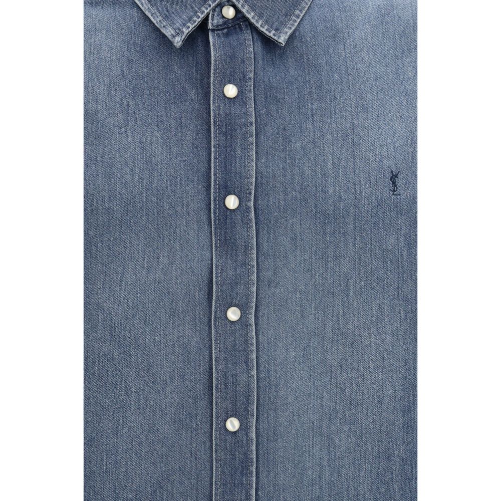 Chemise en denim bleu Saint Laurent, élégante et décontractée, avec détails modernes visibles sur la chemise.
