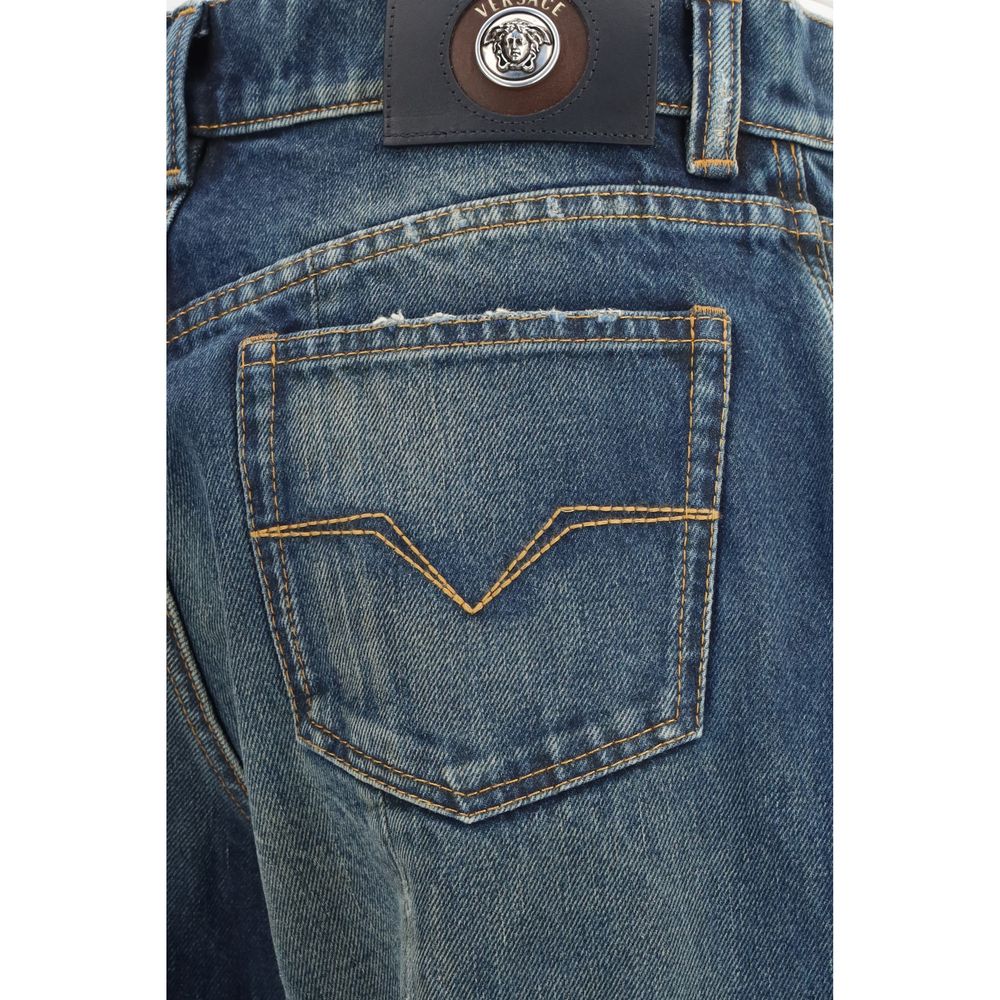 Jeans droits en coton bleu de la marque Versace, visibles avec une coupe classique et détails élégants.