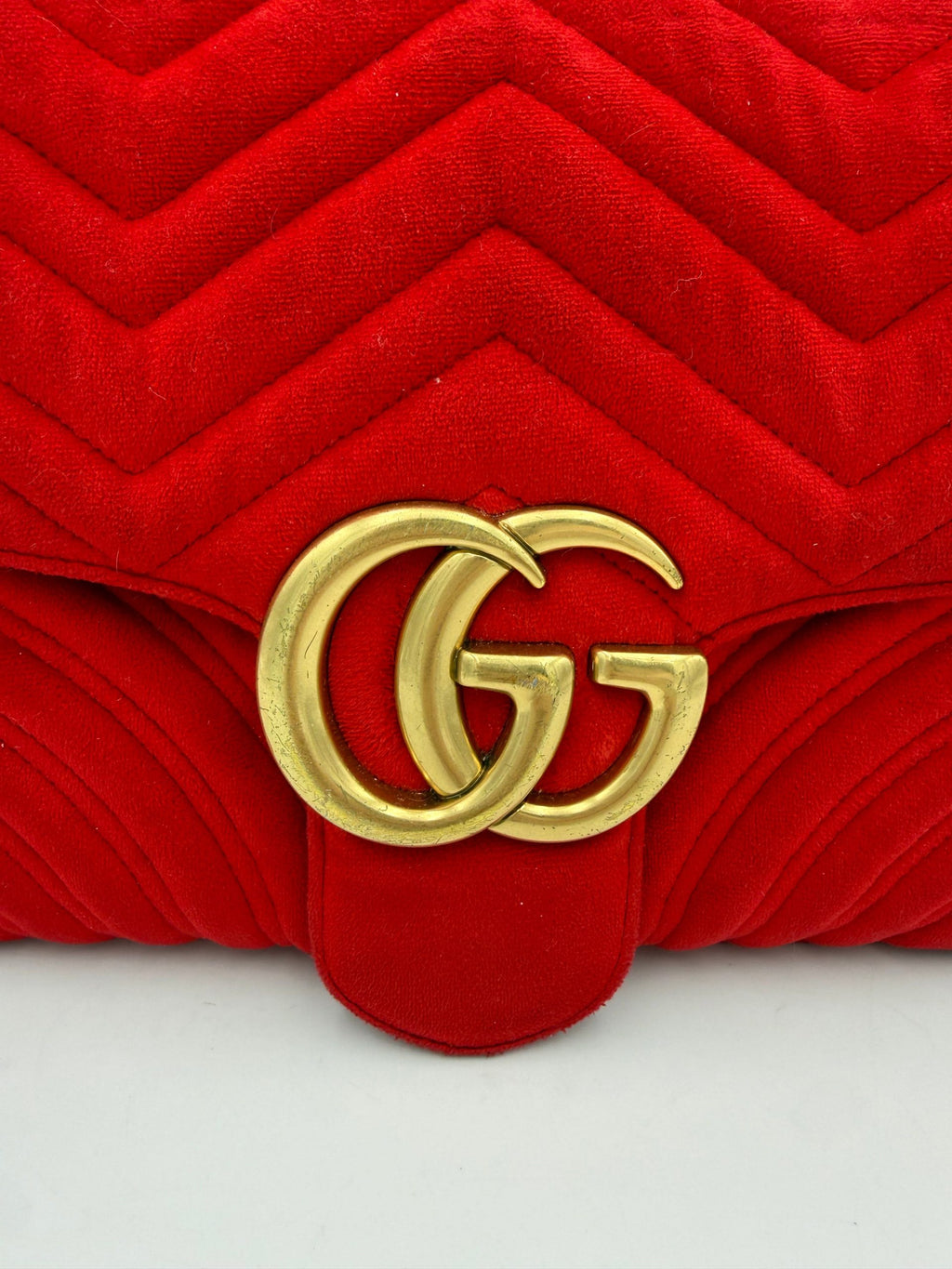 Sac à main en velours rouge Gucci Marmont, élégant et chic, avec logo Gucci visible sur le devant.