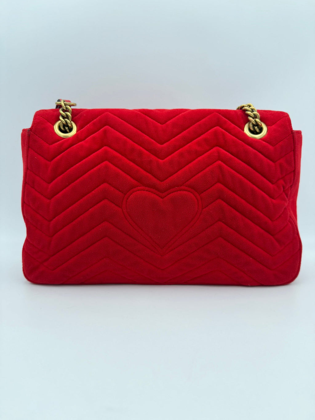 Sac à main Gucci Marmont en velours rouge, design élégant avec logo emblématique et chaîne dorée.
