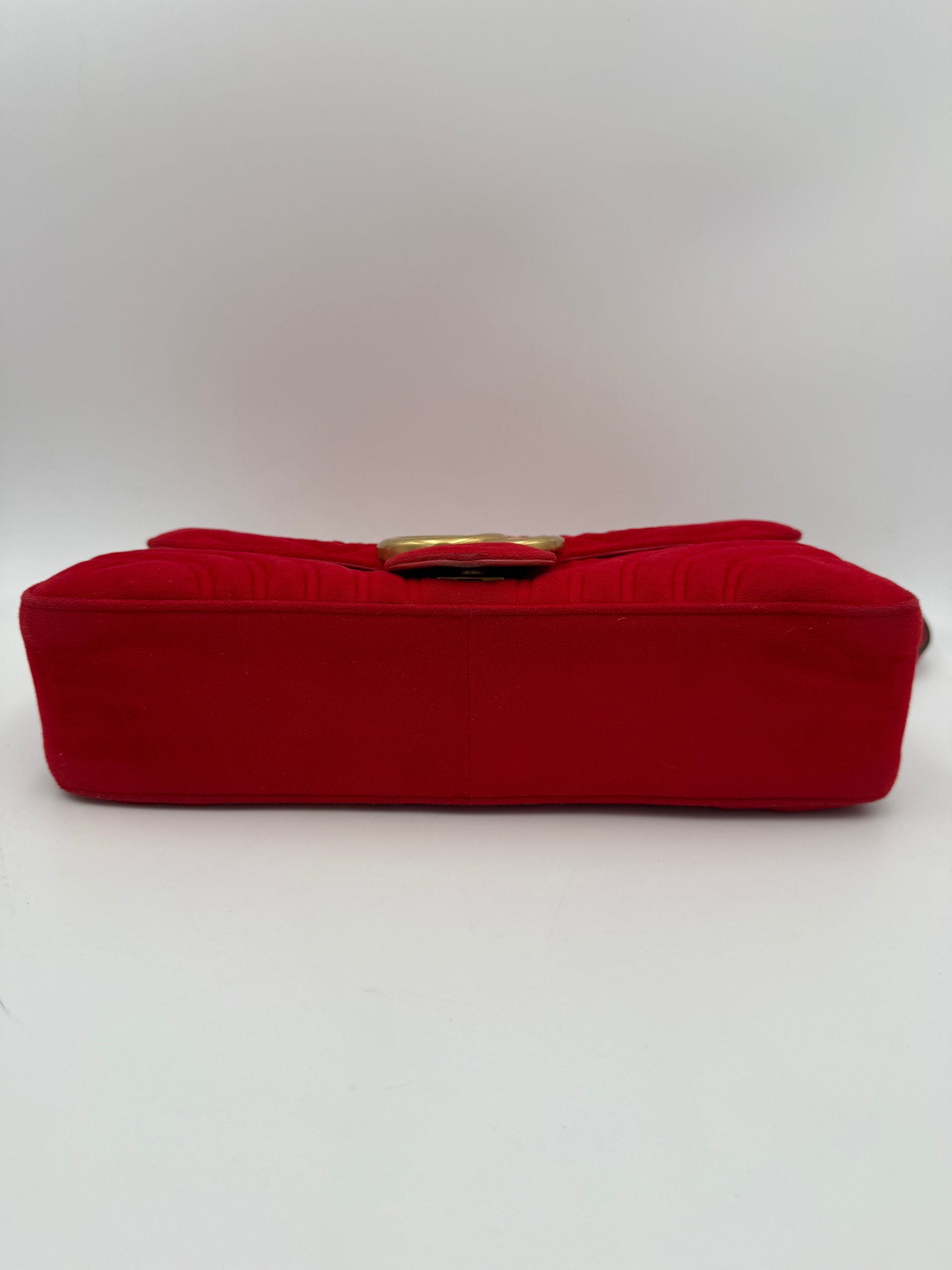 Sac à main Gucci Marmont en velours rouge, design élégant avec logo en métal et bandoulière amovible.