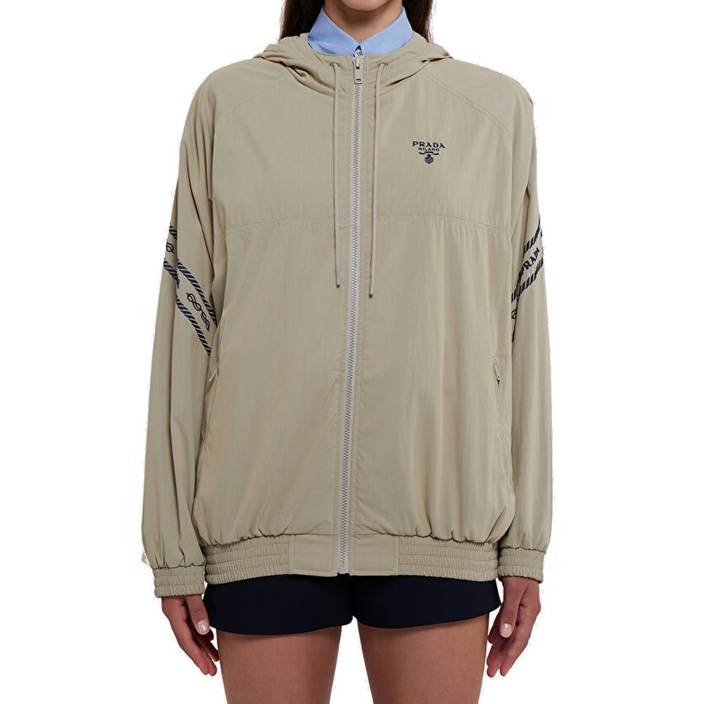 Veste longue en coton beige de Prada, style élégant, visible avec fermeture et détails de finition soignée.