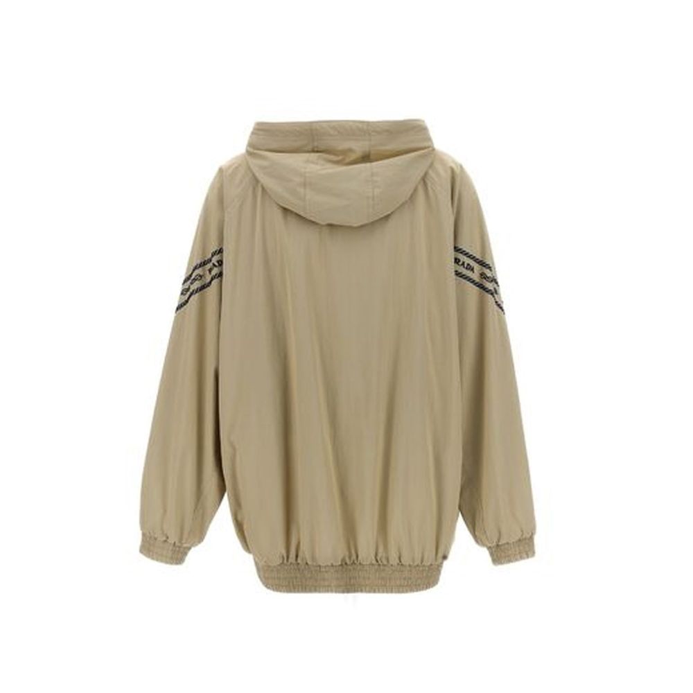 Veste longue en coton beige de Prada, style élégant, visible avec détails de couture et finition sophistiquée.