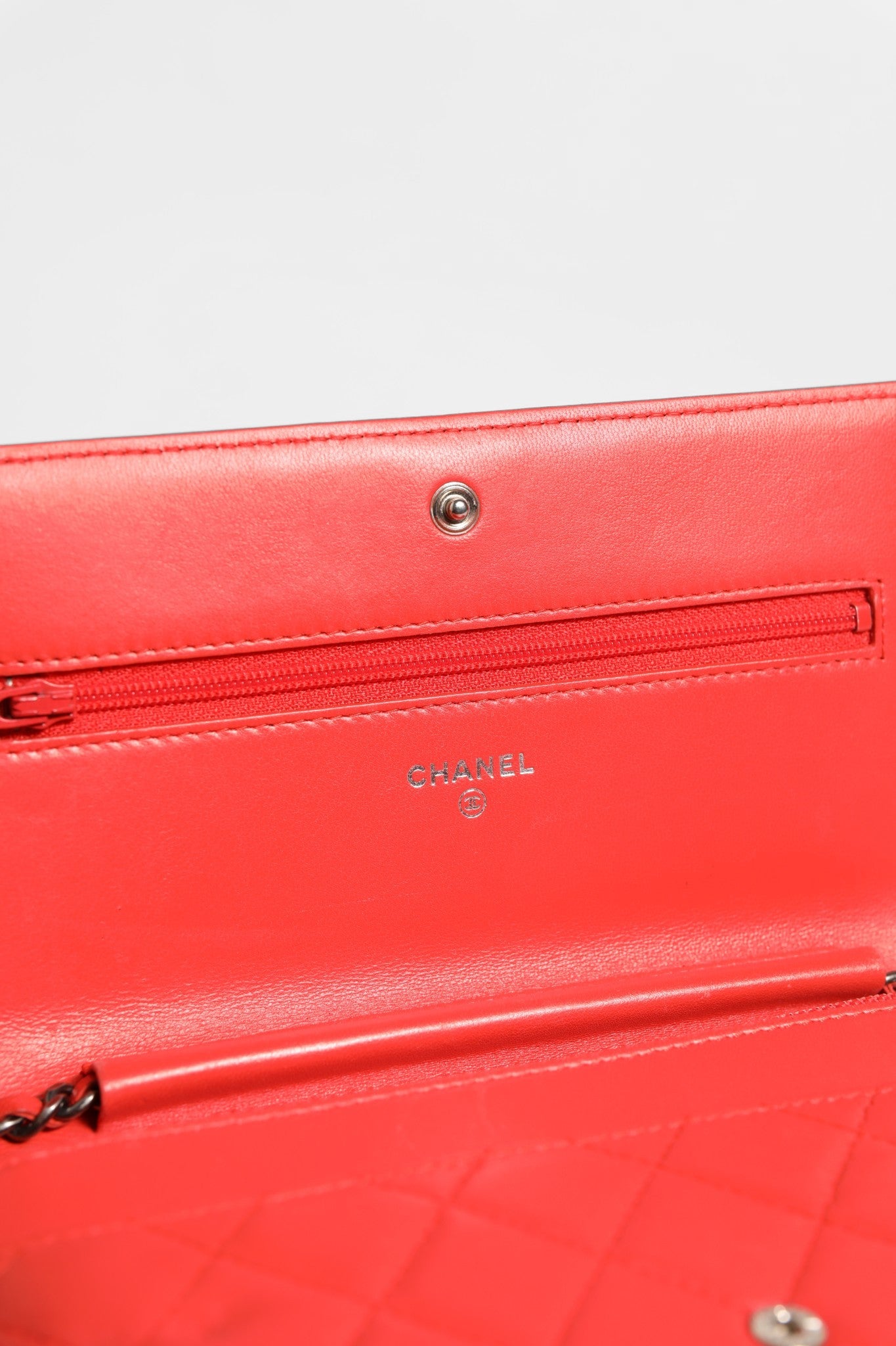 Portefeuille Chanel Boy en cuir d'agneau rouge avec chaîne, élégant et sophistiqué, vue rapprochée du produit.