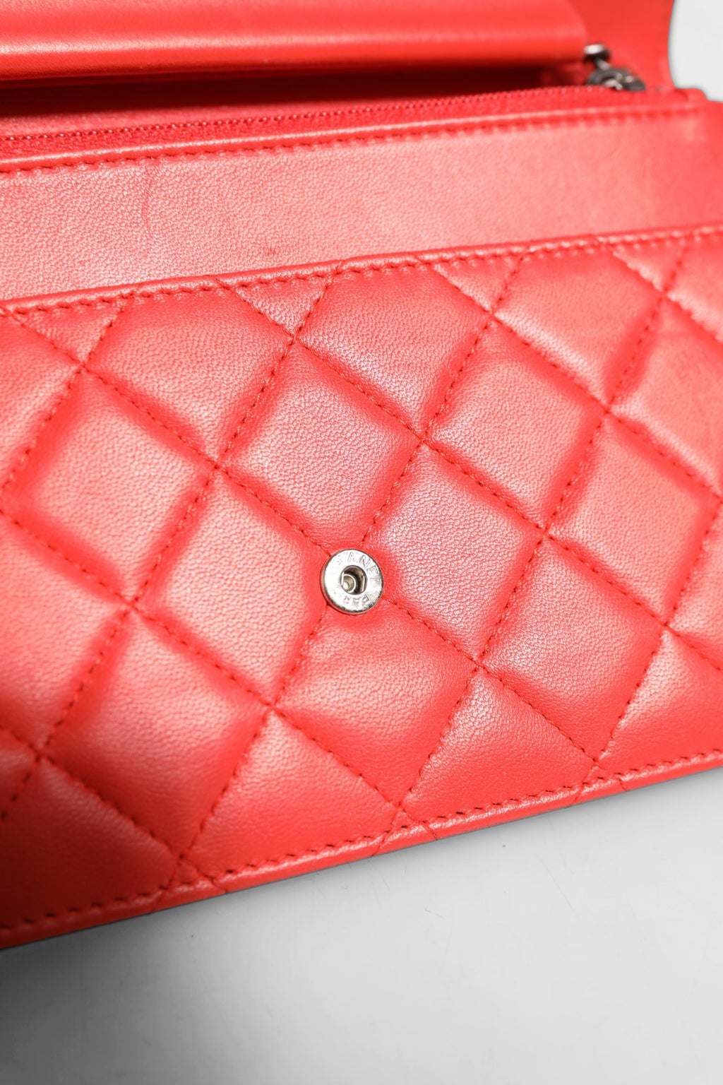 Portefeuille Chanel Boy en cuir d'agneau rouge avec chaîne, élégant et compact pour femmes.