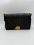 Grand sac à main Chanel Boy de grande taille, en cuir noir avec chaîne en métal, vue de face.