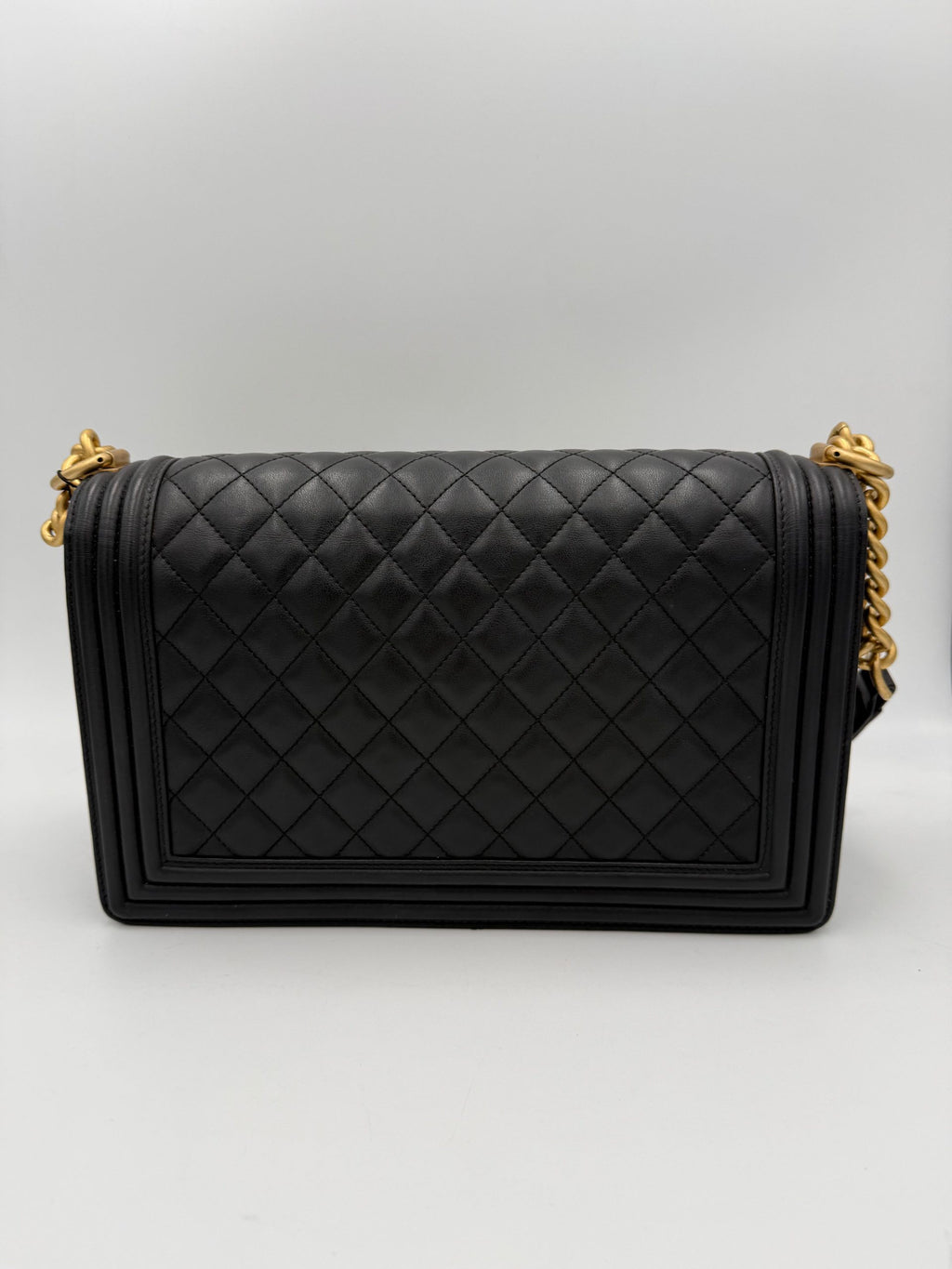 Grand sac à main Chanel Boy de grande taille en cuir noir avec chaîne métallique, vue de face.
