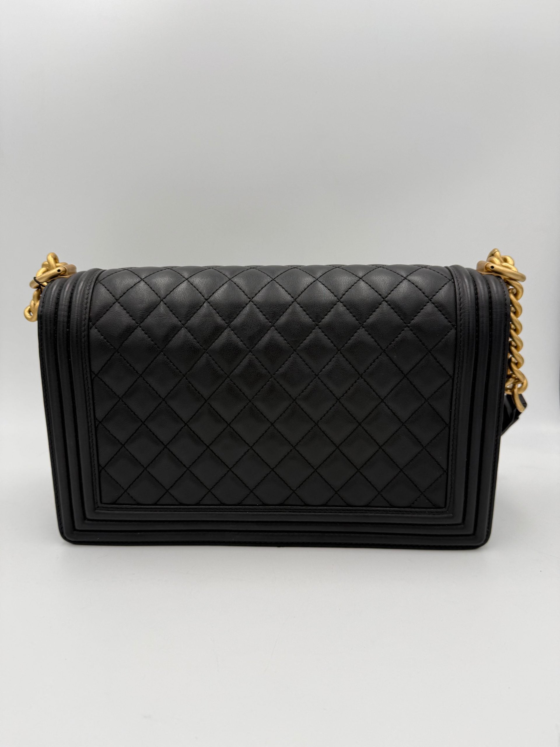 Grand sac à main Chanel Boy de grande taille en cuir noir avec chaîne métallique, vue de face.