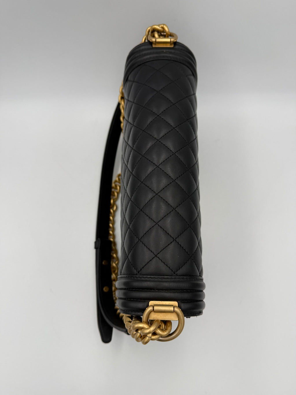 Grand sac à main Chanel Boy en cuir noir avec chaîne métallique et logo emblématique, vue de face.