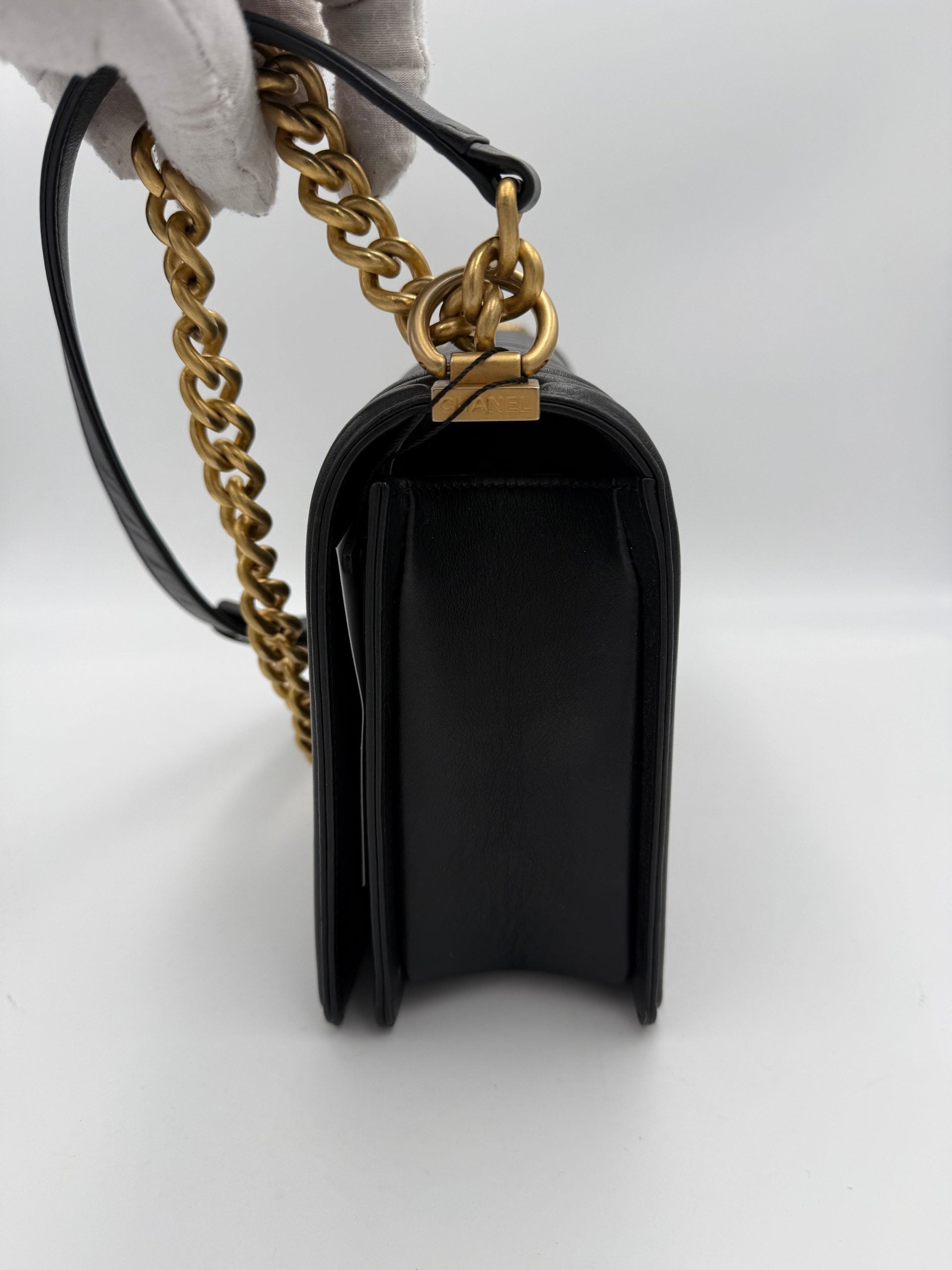 Grand sac à main Chanel Boy de grande taille, en cuir noir avec fermeture à rabat et chaîne dorée, élégant et sophistiqué.