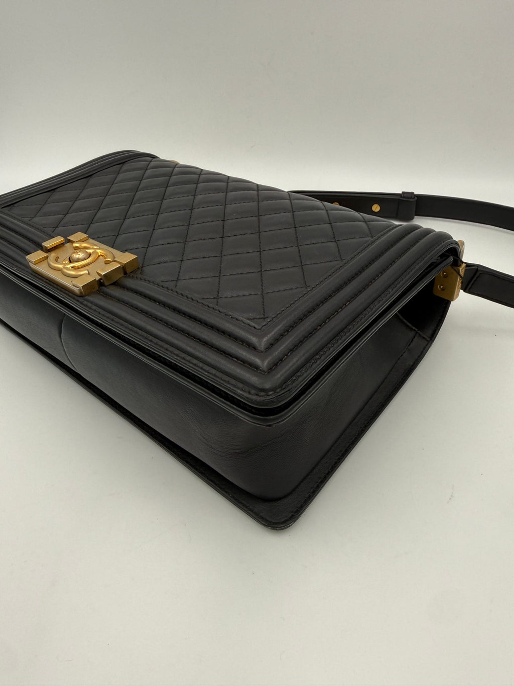 Grand sac à main Chanel Boy, sacoche élégante en cuir avec chaîne dorée, porté sur l'épaule ou à la main.