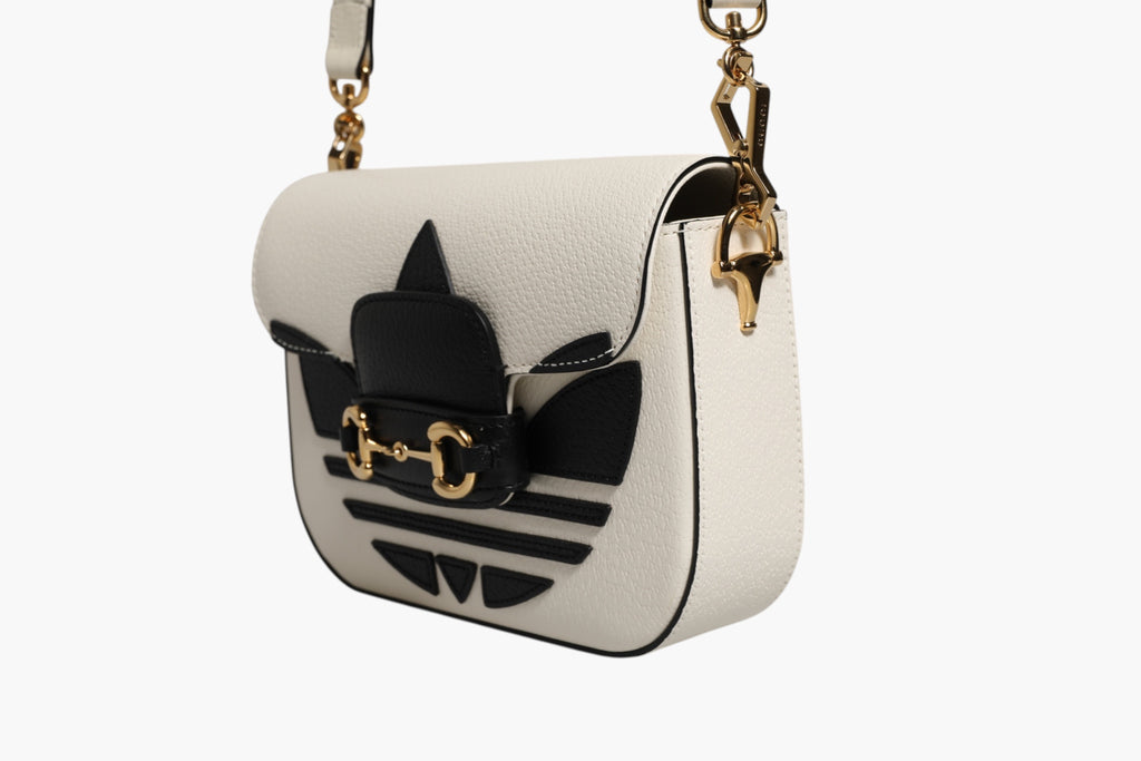 Sac à bandoulière Gucci x Adidas Horsebit 1955 en cuir blanc et noir, design élégant avec détails Horsebit.