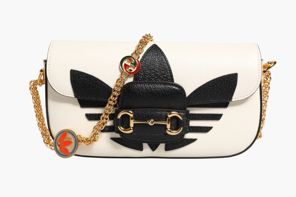 Sac à épaules Gucci x Adidas Horsebit 1955 en cuir blanc et noir, avec détails en métal, élégant et tendance.